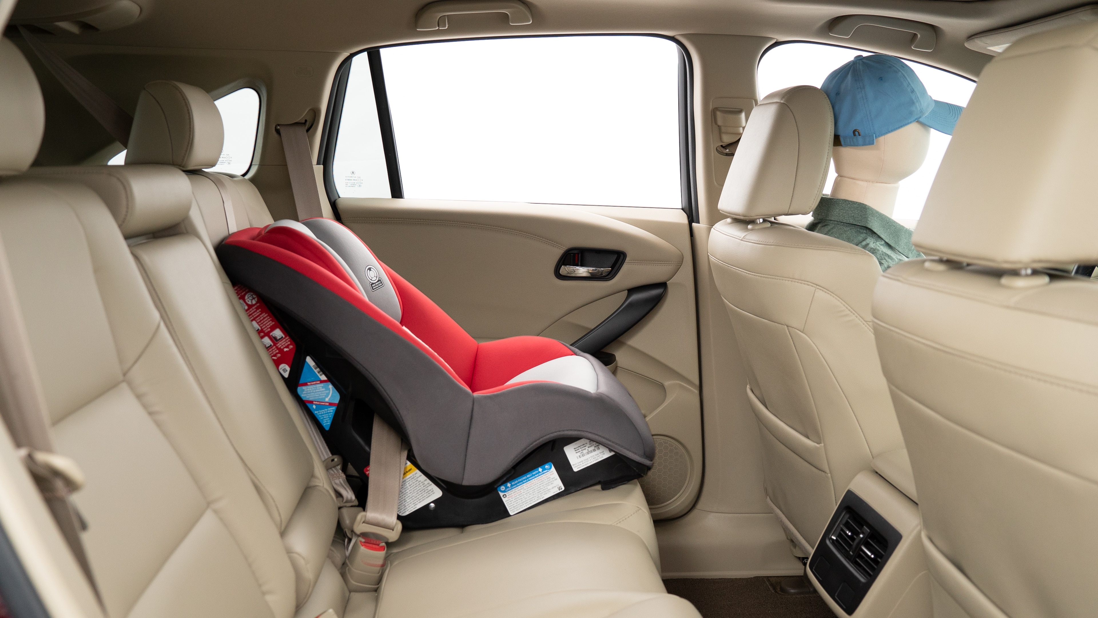 A series of second-row backseat photos is shown including one seating a baby seat, a dog and one seating a 6'1" mannequin.