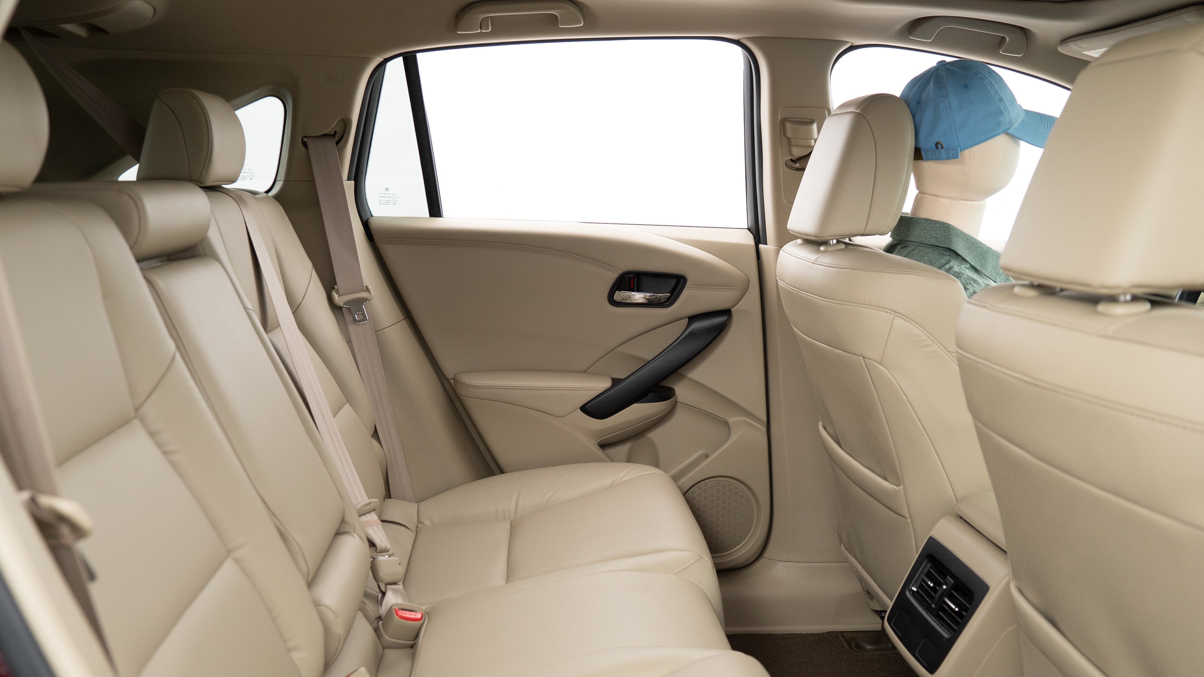 A series of second-row backseat photos is shown including one seating a baby seat, a dog and one seating a 6'1" mannequin.