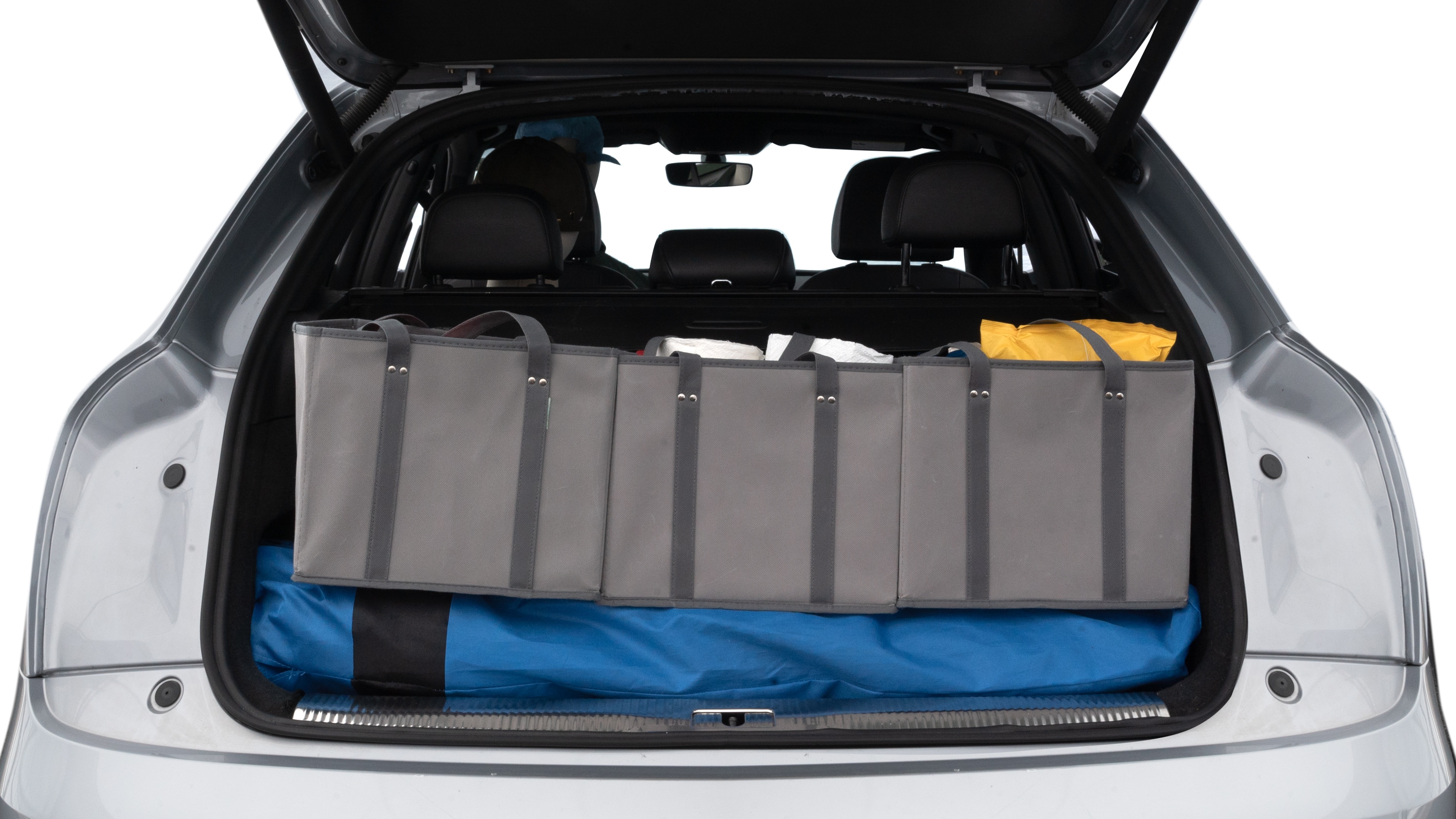 The trunk lid is open showing full view of the trunk. A baby stroller, three grocery carriers, two camping chairs in the carrying bag, and a set of golf clubs are placed inside.