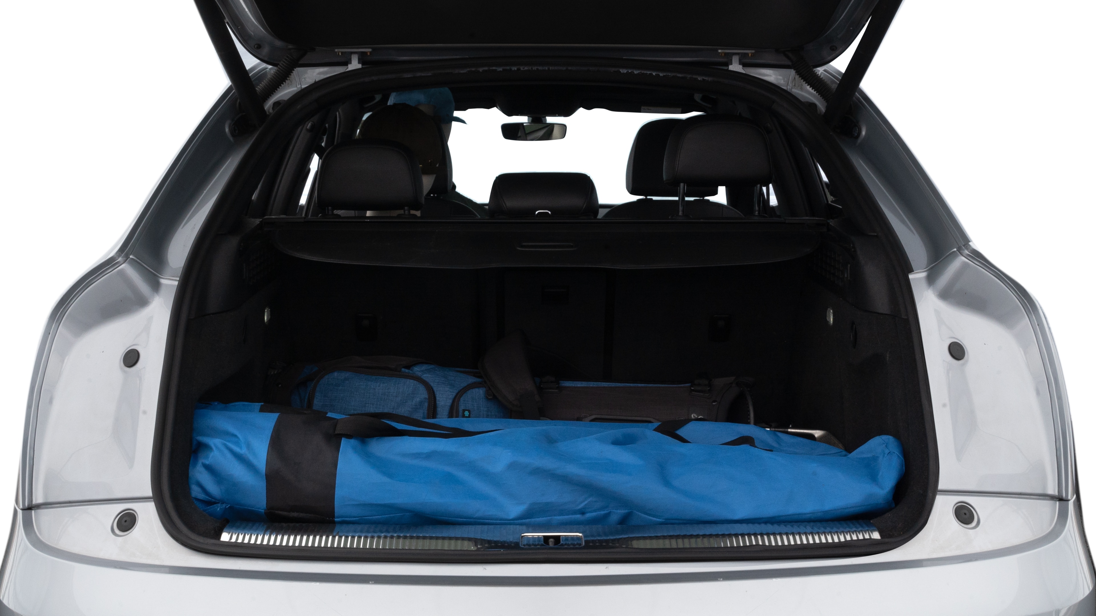 The trunk lid is open showing full view of the trunk. A baby stroller, three grocery carriers, two camping chairs in the carrying bag, and a set of golf clubs are placed inside.