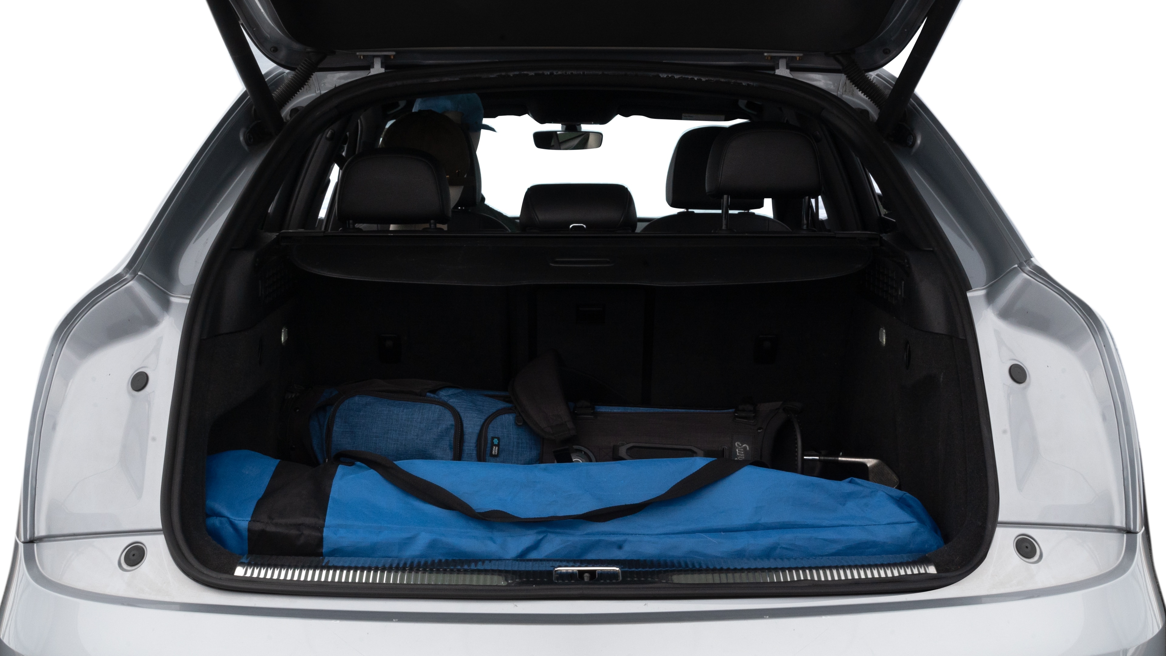The trunk lid is open showing full view of the trunk. A baby stroller, three grocery carriers, two camping chairs in the carrying bag, and a set of golf clubs are placed inside.