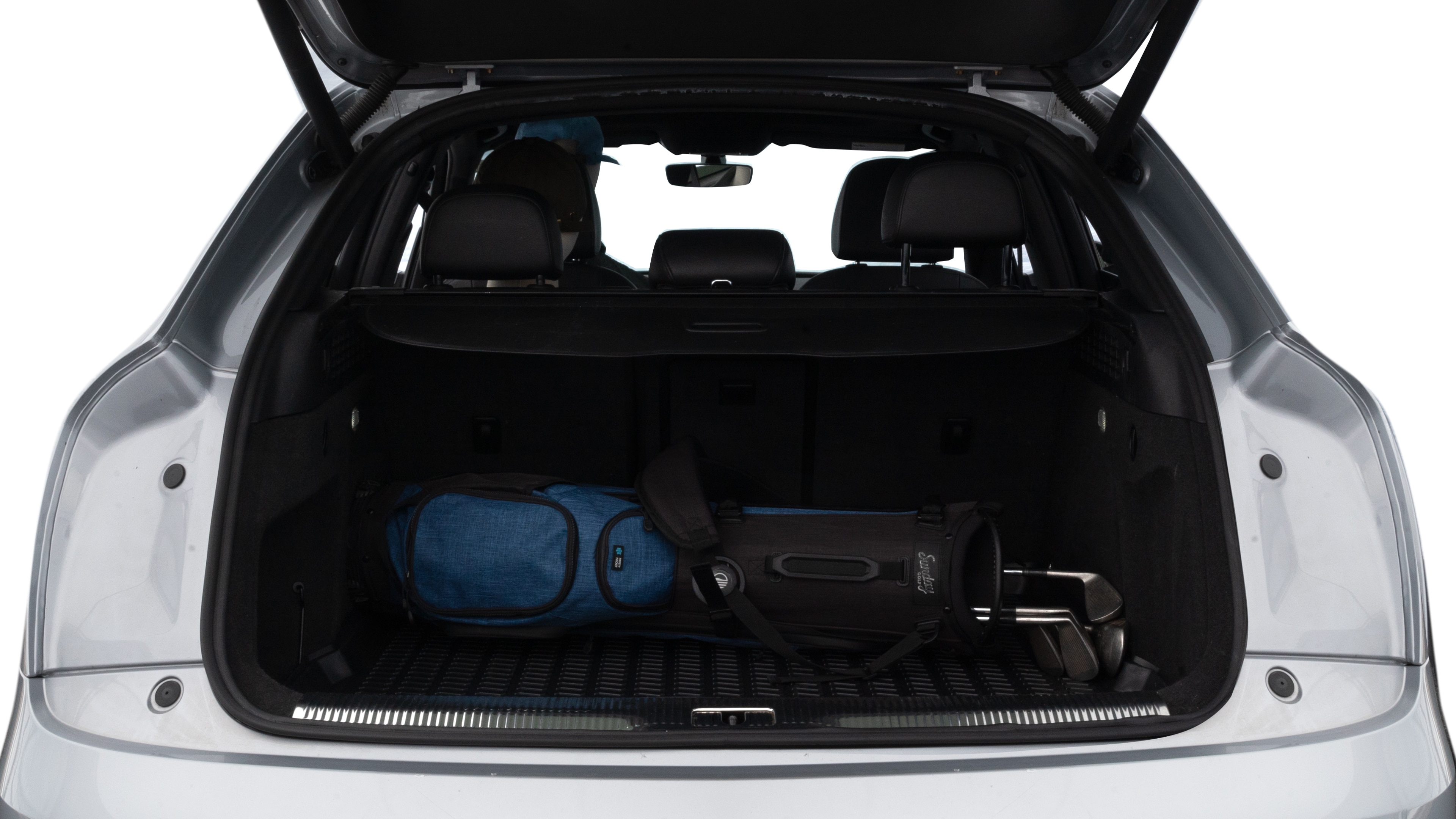 The trunk lid is open showing full view of the trunk. A baby stroller, three grocery carriers, two camping chairs in the carrying bag, and a set of golf clubs are placed inside.
