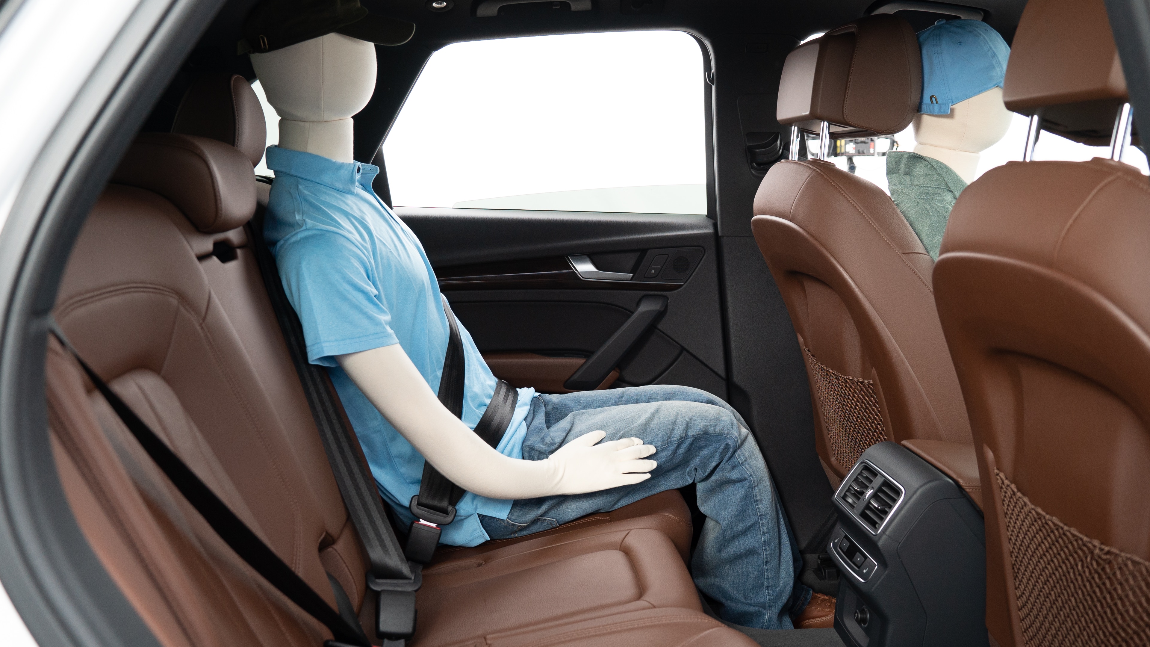 A series of second-row backseat photos is shown including one seating a baby seat, a dog and one seating a 6'1" mannequin.