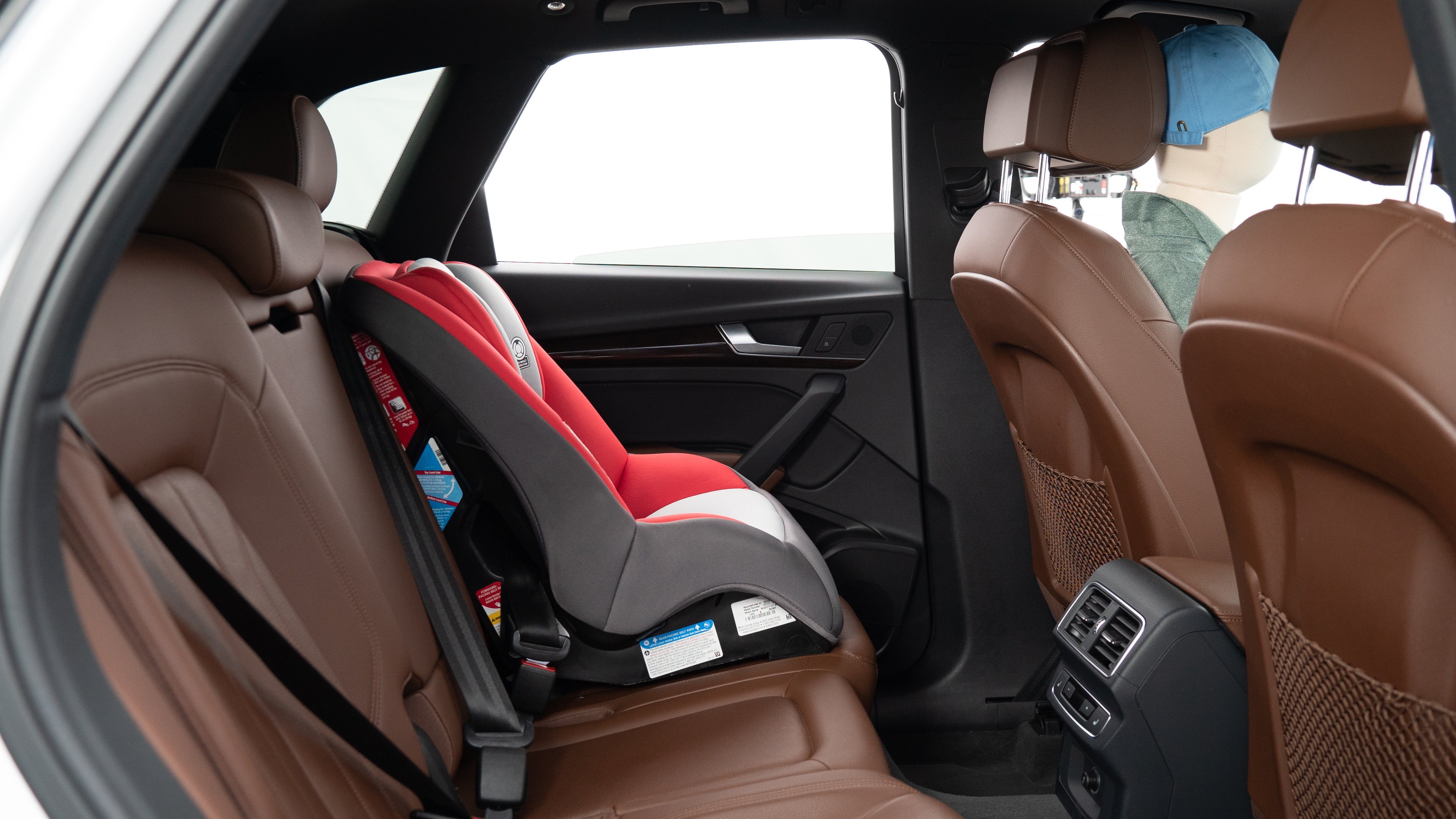 A series of second-row backseat photos is shown including one seating a baby seat, a dog and one seating a 6'1" mannequin.