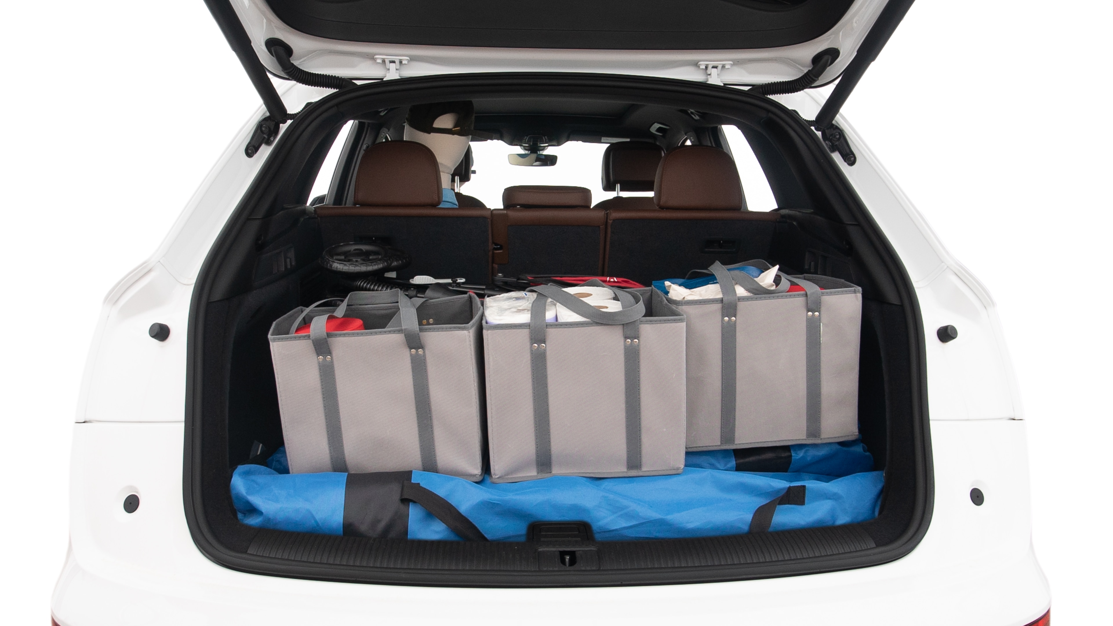 The trunk lid is open showing full view of the trunk. A baby stroller, three grocery carriers, two camping chairs in the carrying bag, and a set of golf clubs are placed inside.