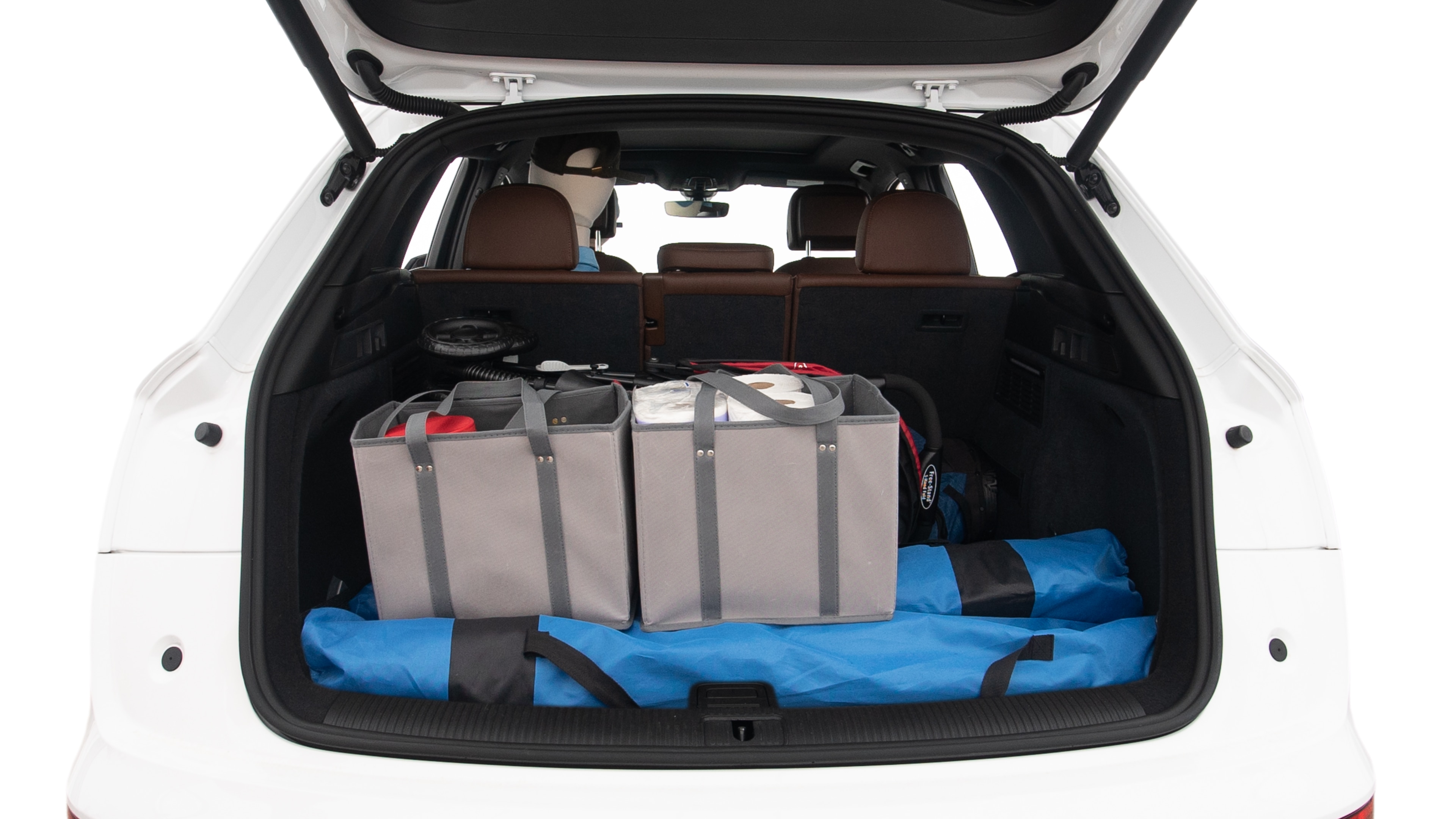 The trunk lid is open showing full view of the trunk. A baby stroller, three grocery carriers, two camping chairs in the carrying bag, and a set of golf clubs are placed inside.