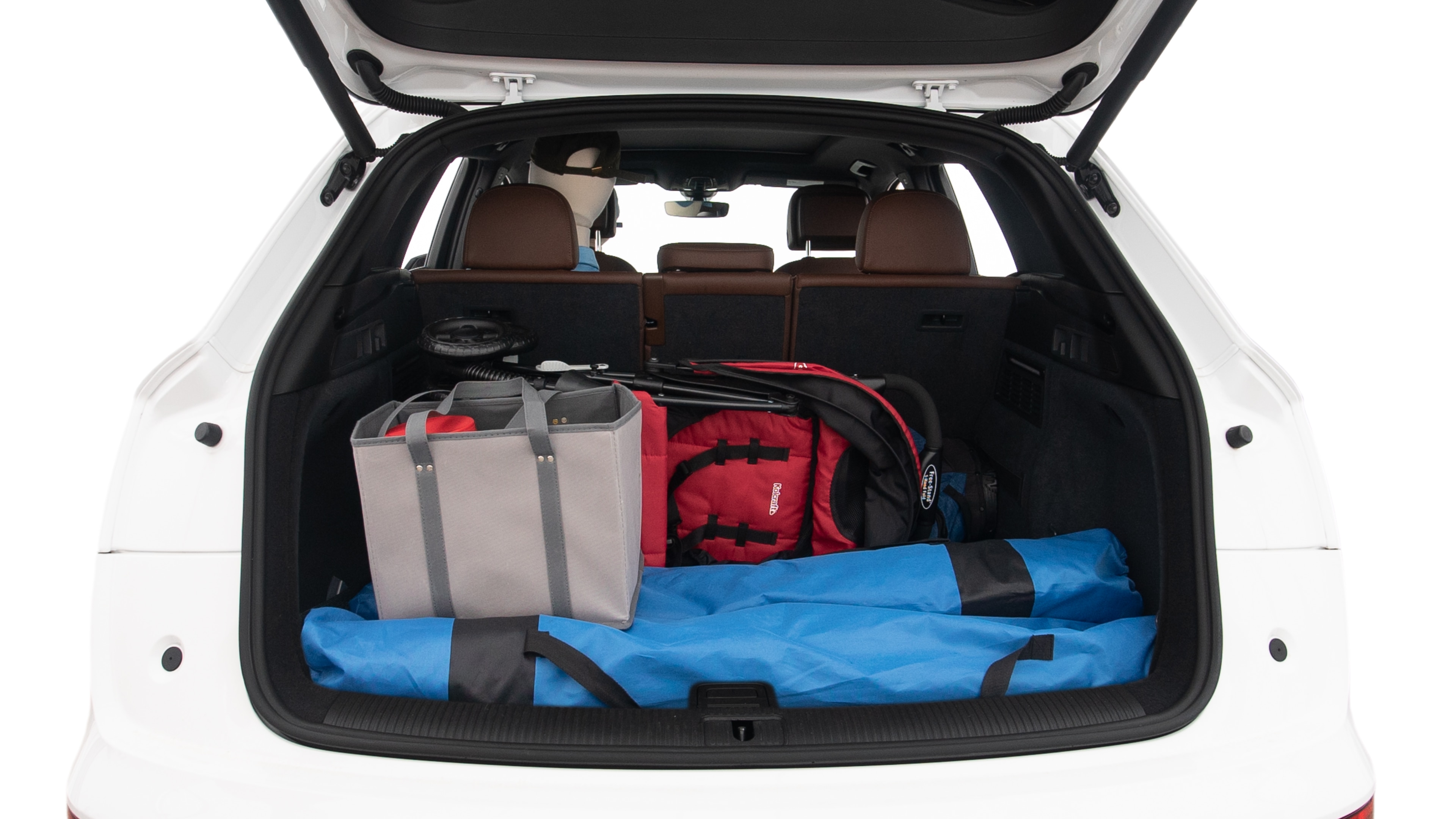 The trunk lid is open showing full view of the trunk. A baby stroller, three grocery carriers, two camping chairs in the carrying bag, and a set of golf clubs are placed inside.