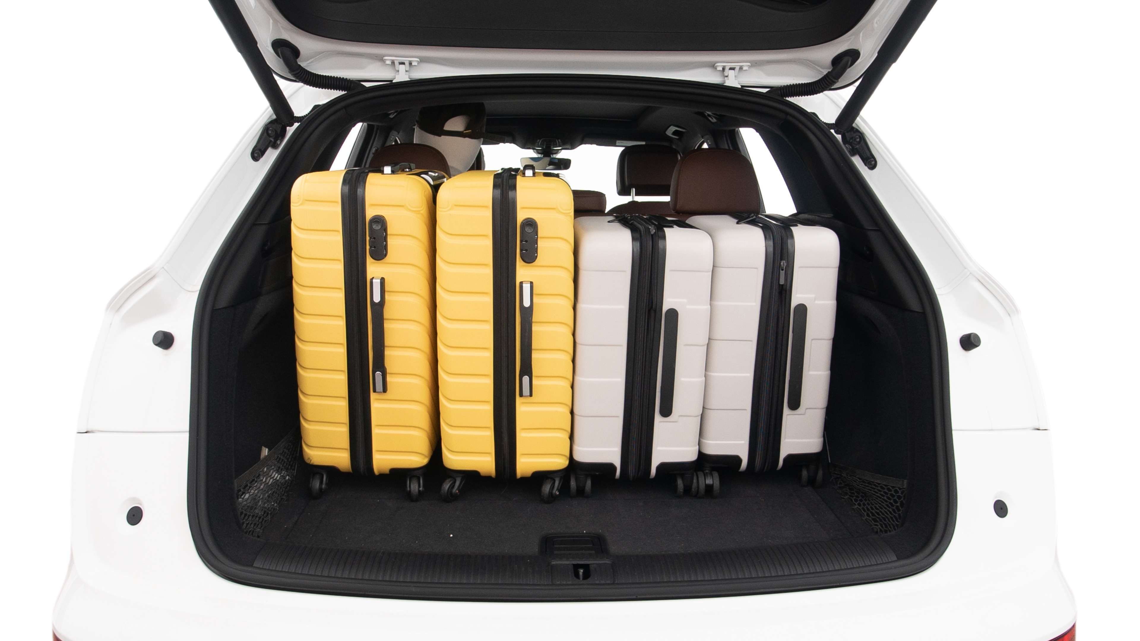 The trunk lid is open, showing full view of the trunk space. Two large and two small suitcases are placed inside.