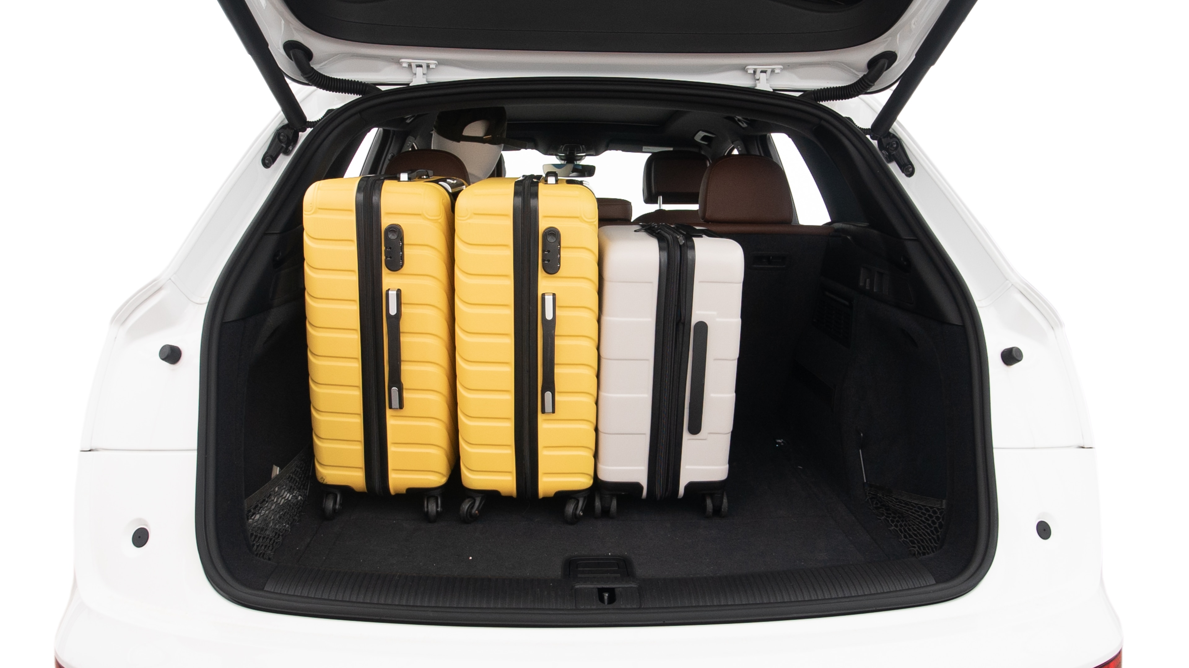 The trunk lid is open, showing full view of the trunk space. Two large and two small suitcases are placed inside.