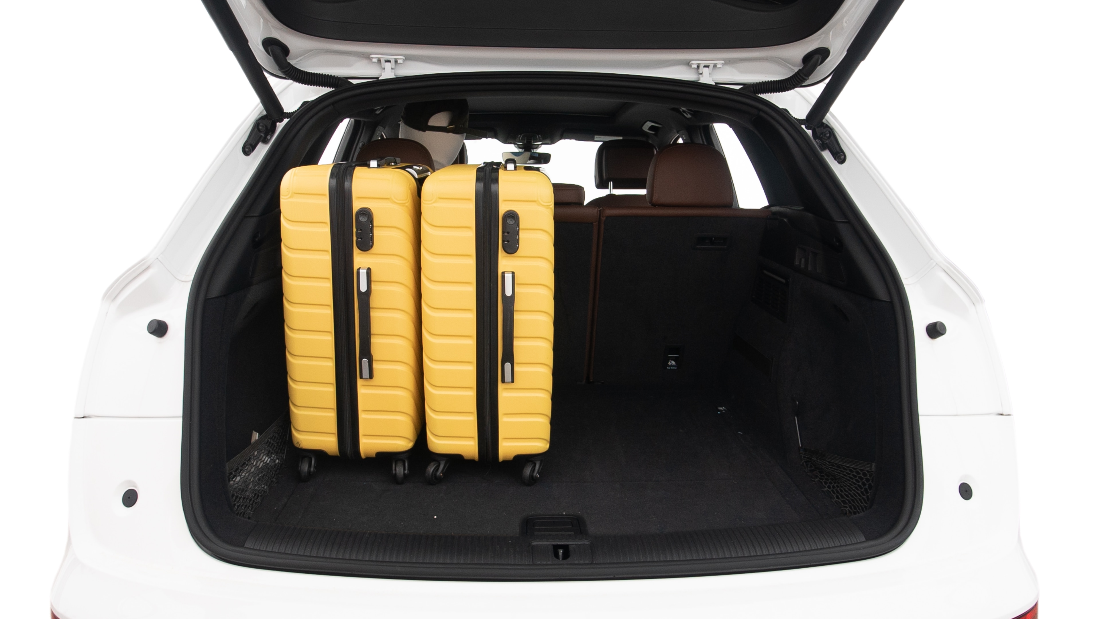 The trunk lid is open, showing full view of the trunk space. Two large and two small suitcases are placed inside.