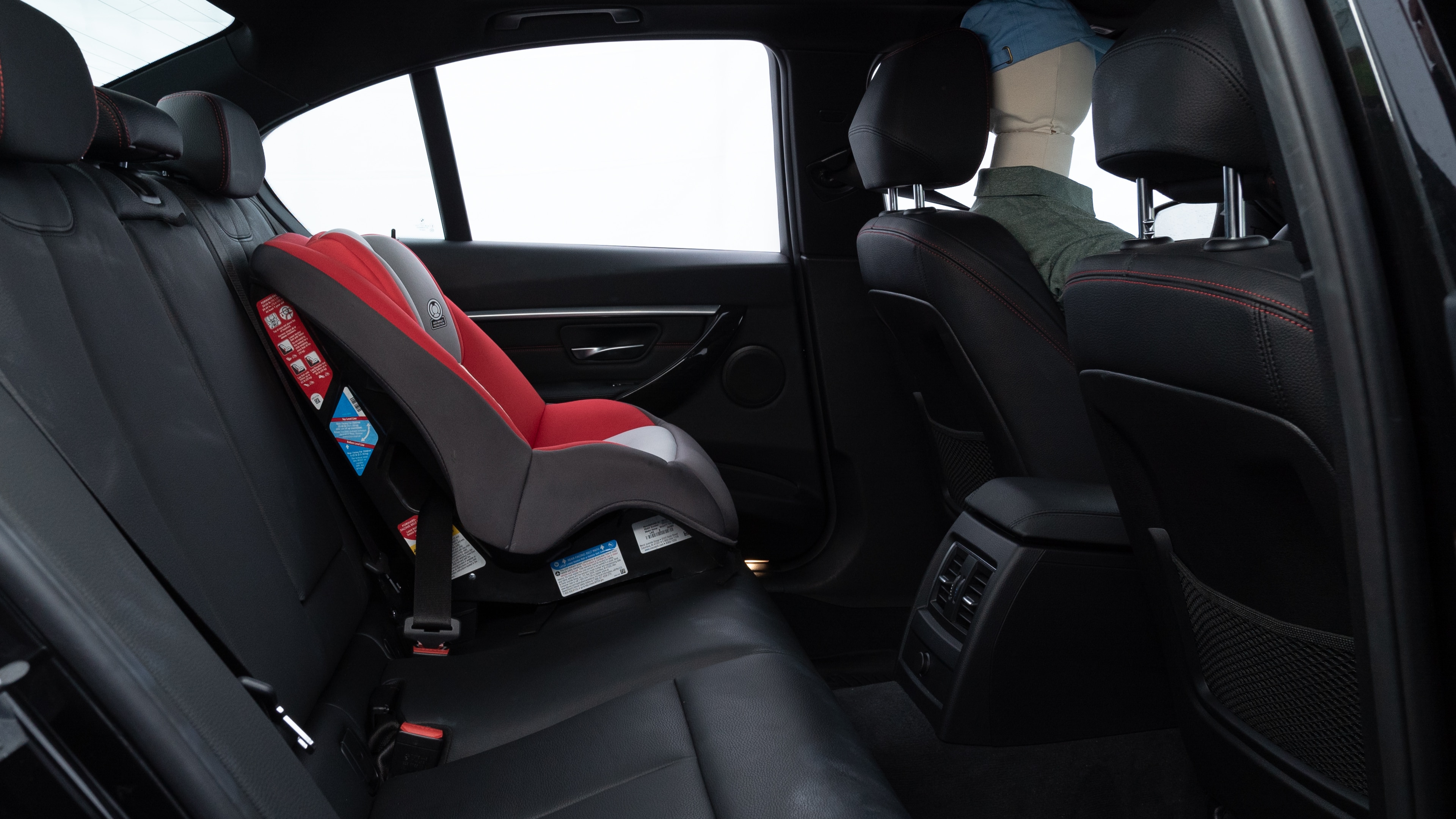 A series of second-row backseat photos is shown including one seating a baby seat and one seating a 6'1" mannequin.