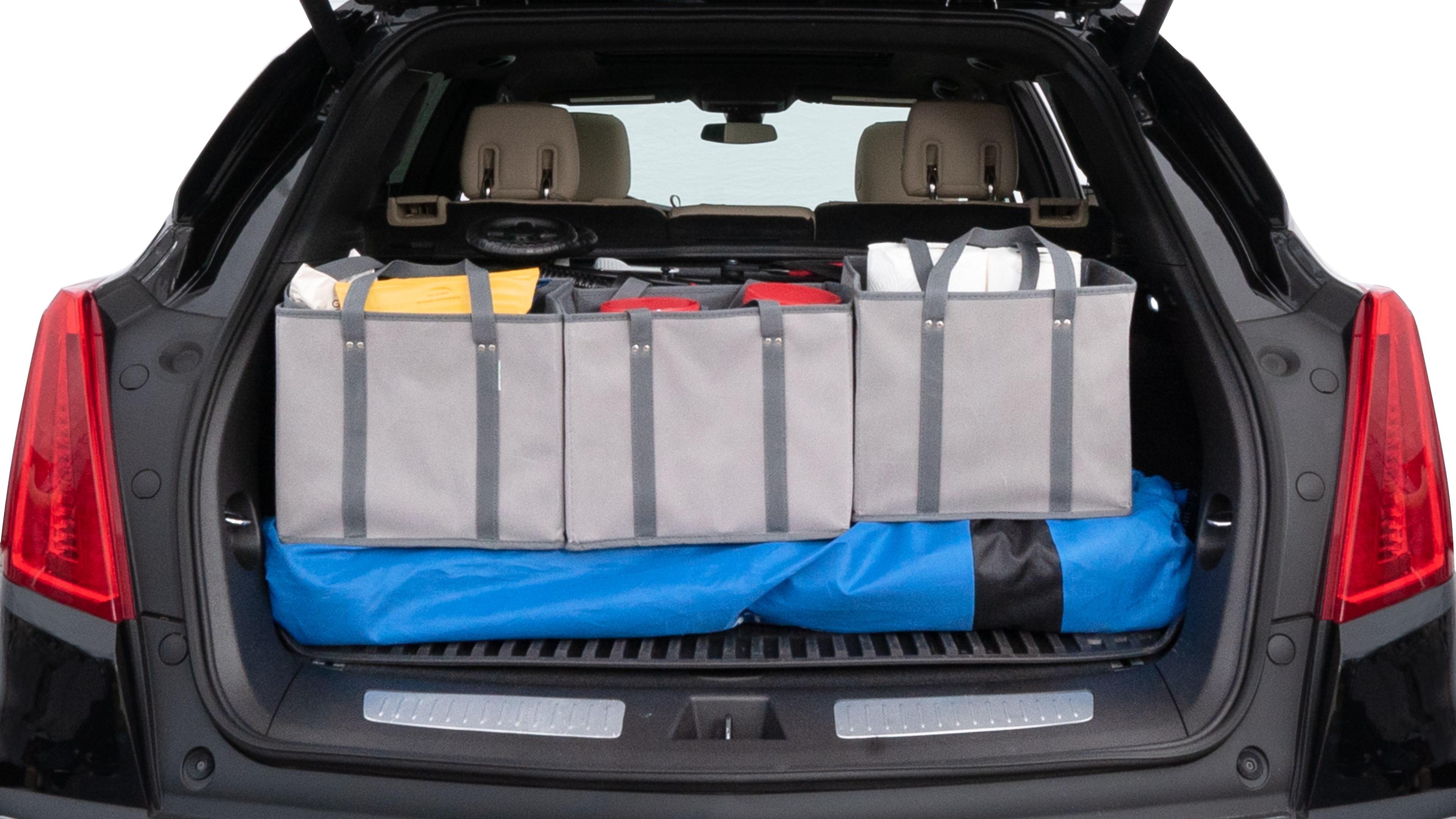 The trunk lid is open showing full view of the trunk. A baby stroller, three grocery carriers, two camping chairs in the carrying bag, and a set of golf clubs are placed inside.