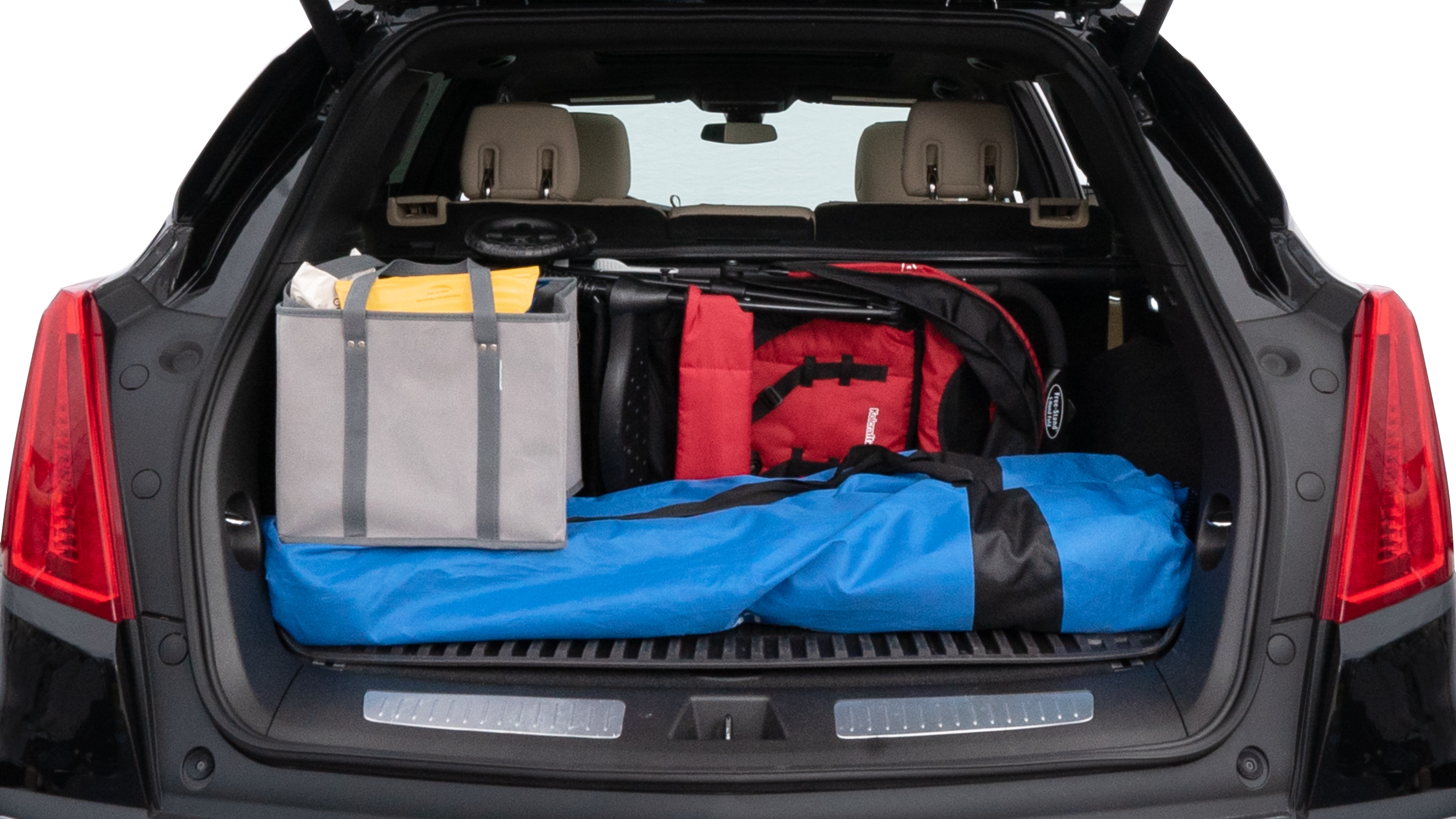 The trunk lid is open showing full view of the trunk. A baby stroller, three grocery carriers, two camping chairs in the carrying bag, and a set of golf clubs are placed inside.