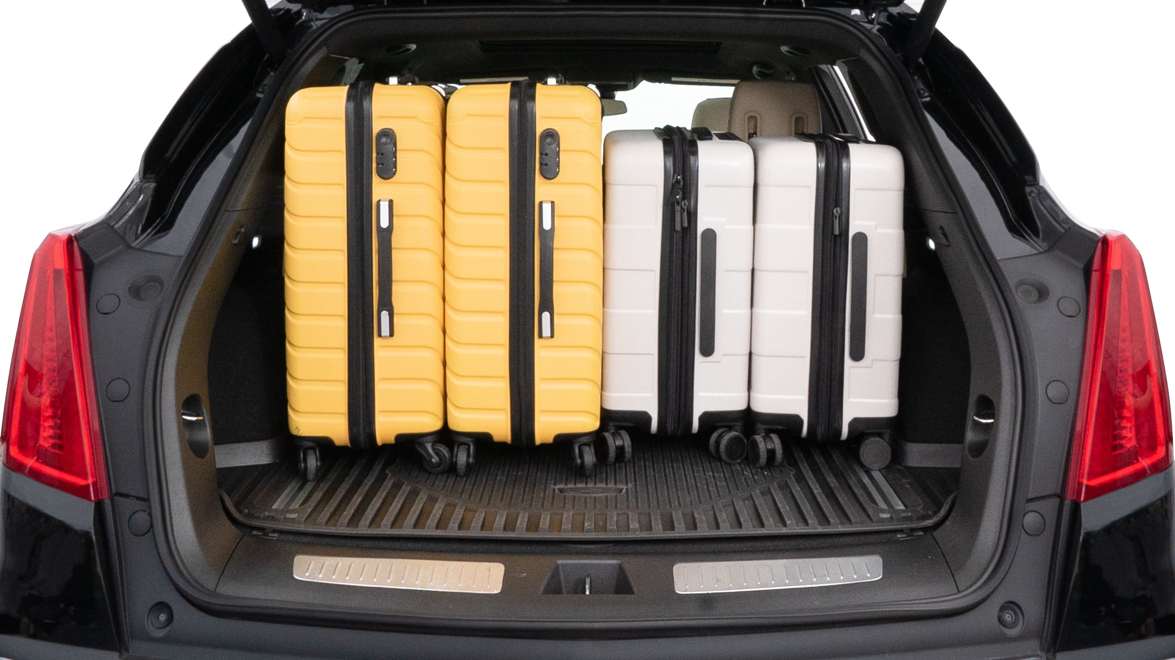 The trunk lid is open, showing full view of the trunk space. Two medium and two small suitcases are placed inside.