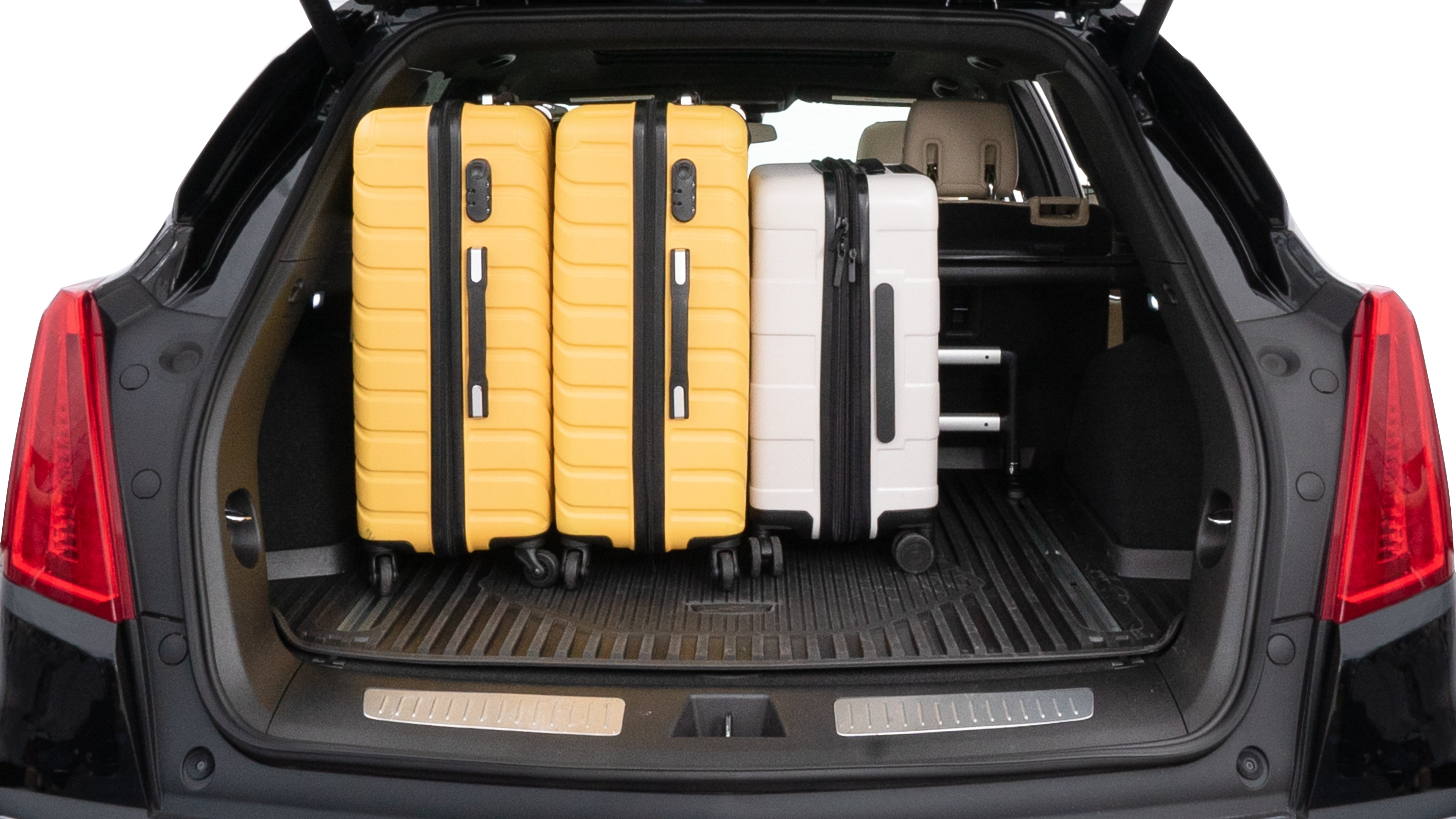The trunk lid is open, showing full view of the trunk space. Two medium and two small suitcases are placed inside.
