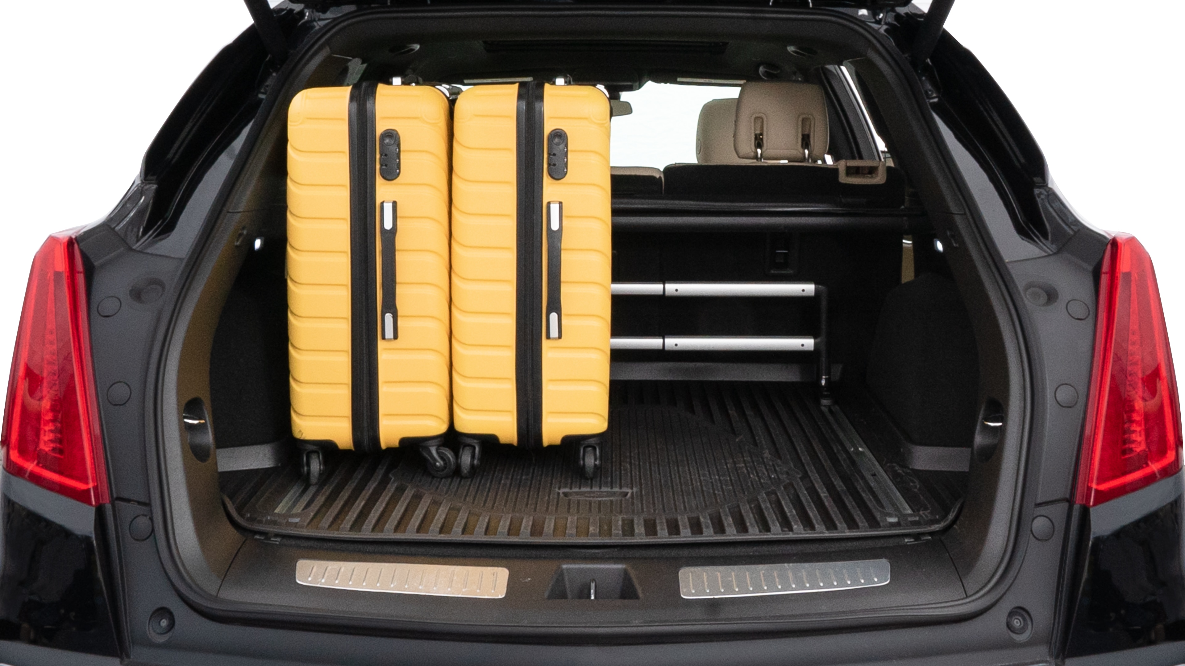 The trunk lid is open, showing full view of the trunk space. Two medium and two small suitcases are placed inside.