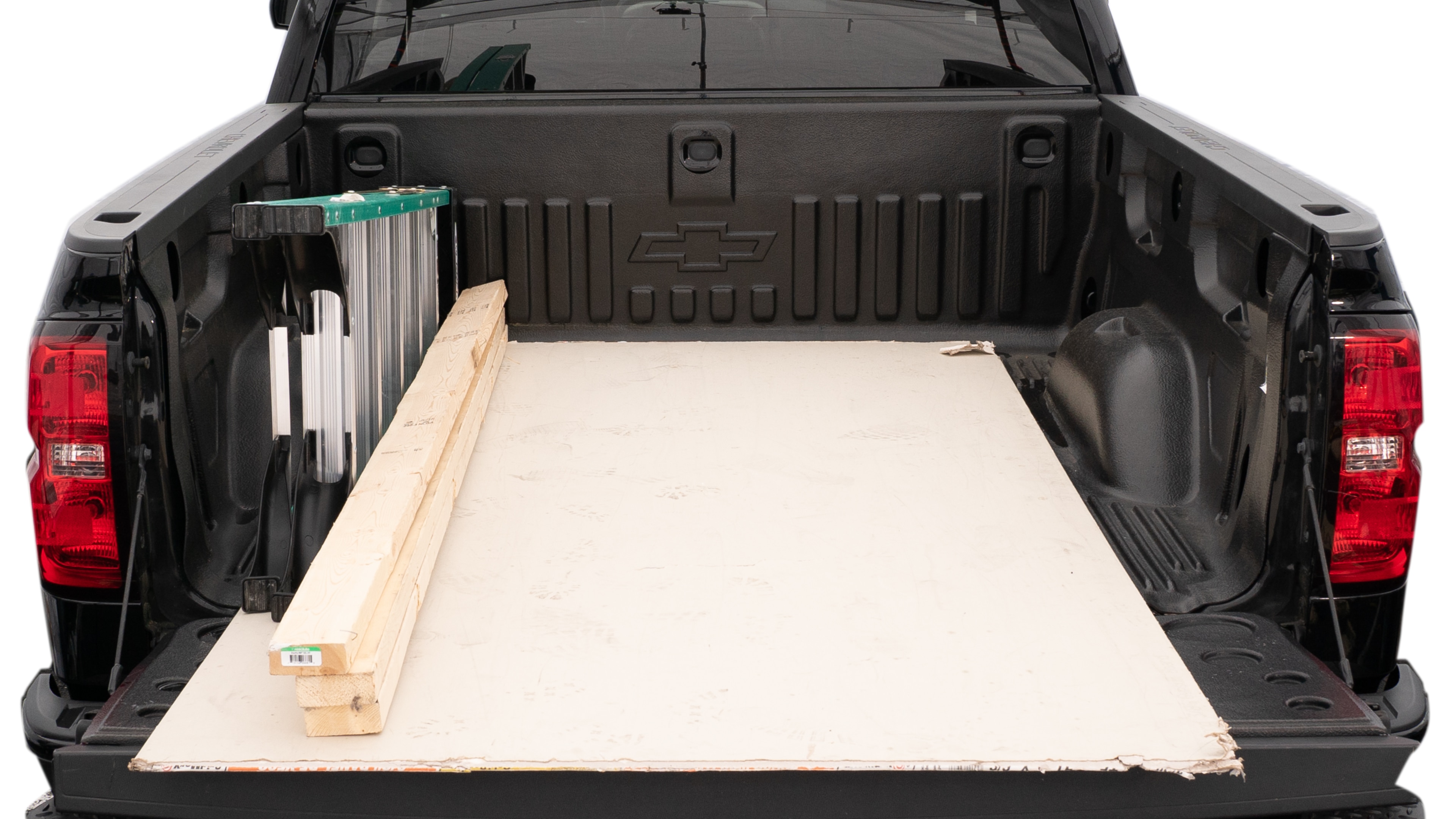 The trunk area is open giving a full view of the trunk area. A ladder, three 2 by 4 framing studs, two tool box and a 4 by 8 drywall sheet are placed inside.