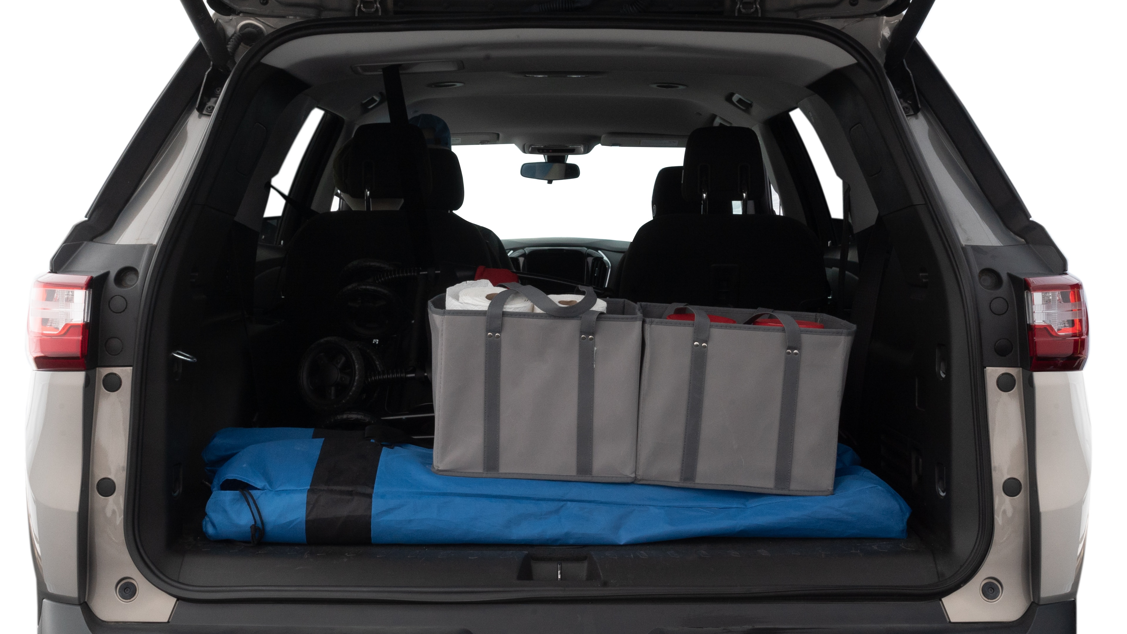 The trunk lid is open showing full view of the trunk. A baby stroller, three grocery carriers, two camping chairs in the carrying bag, and a set of golf clubs are placed inside.