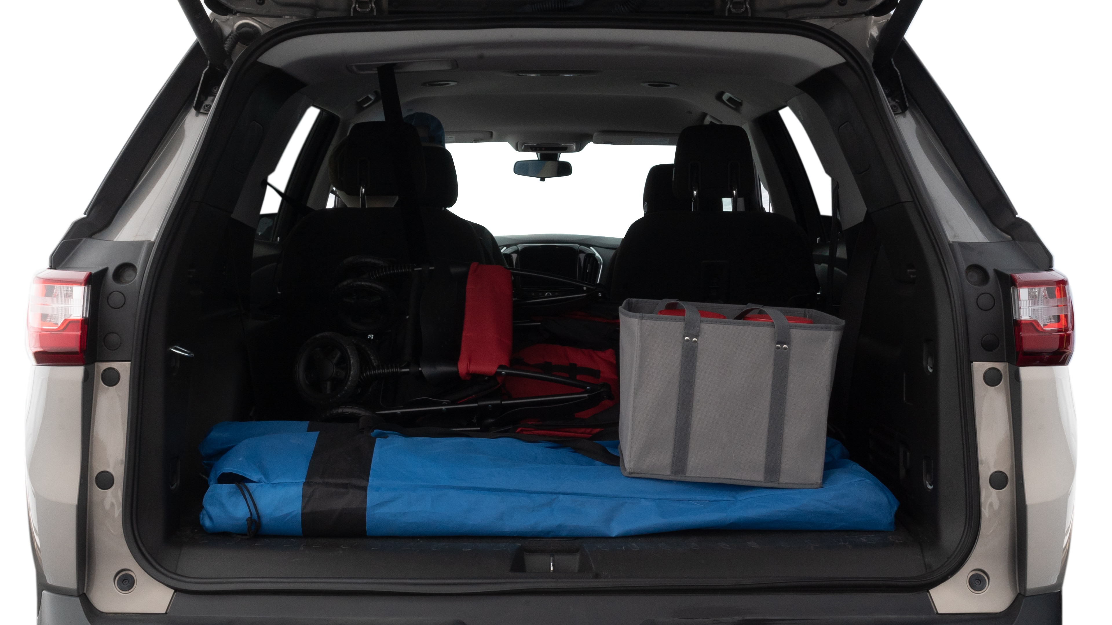 The trunk lid is open showing full view of the trunk. A baby stroller, three grocery carriers, two camping chairs in the carrying bag, and a set of golf clubs are placed inside.