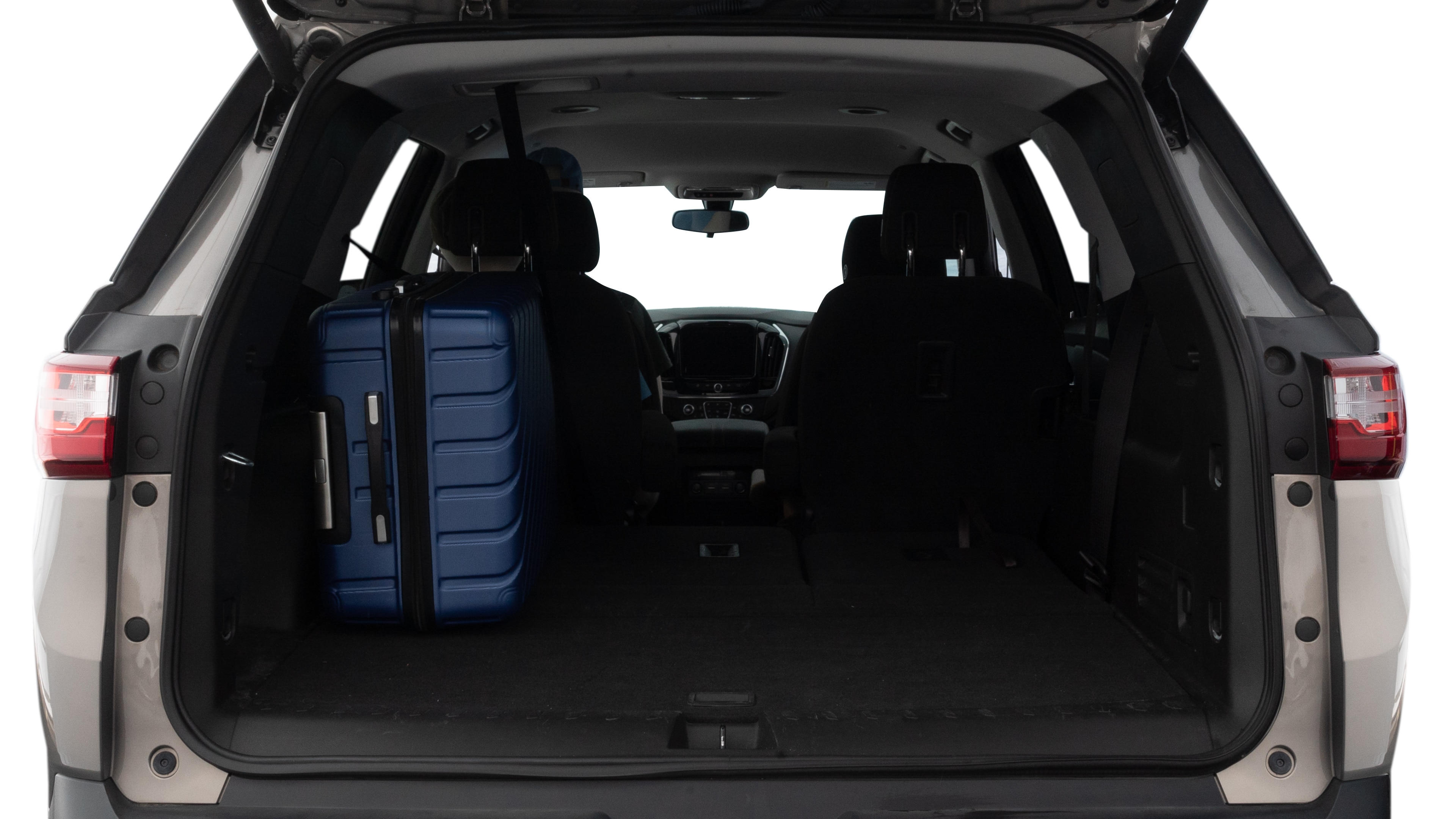 The trunk lid is open, showing full view of the trunk space. One large, two medium, and one small suitcases are placed inside.