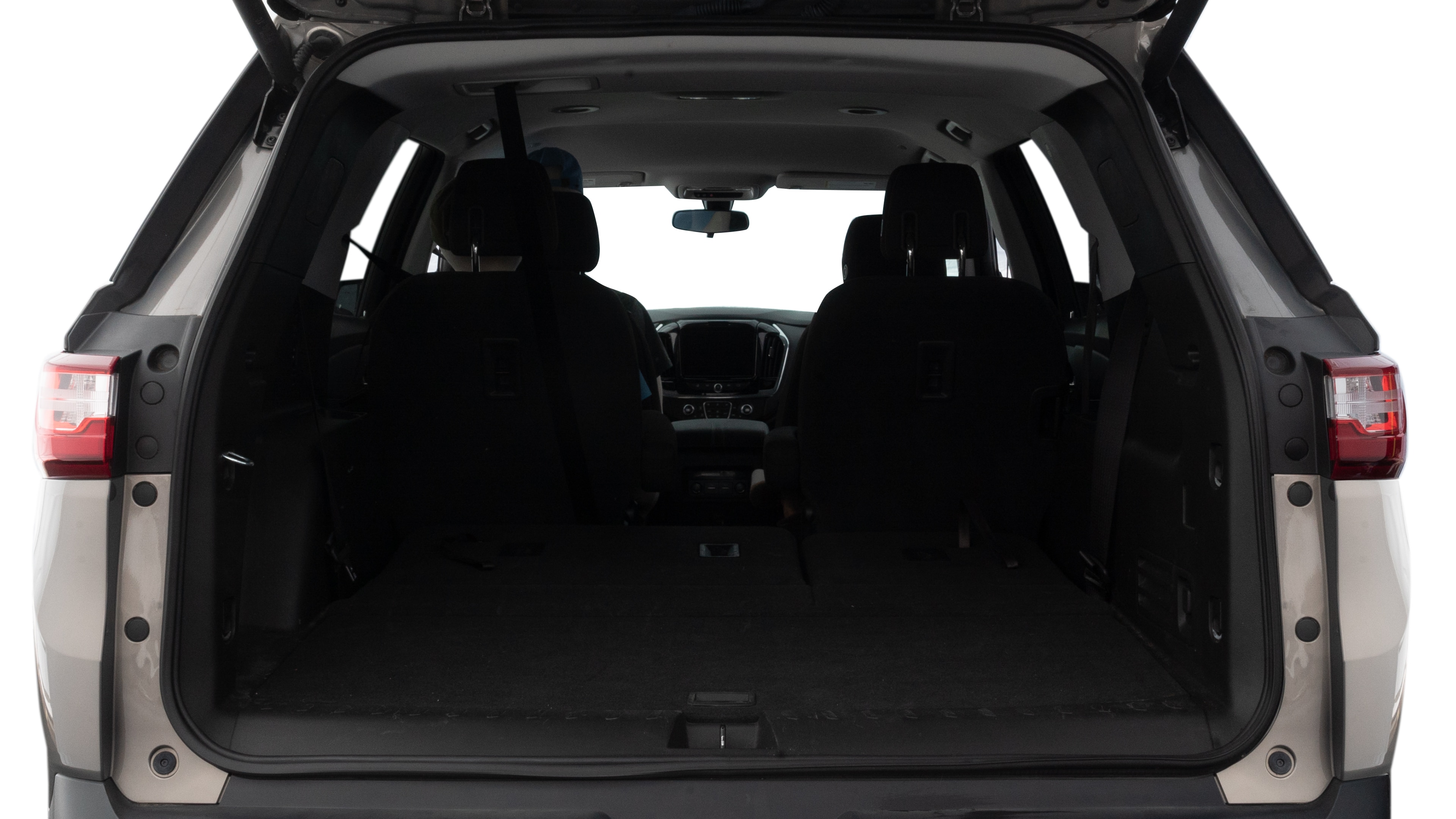 The trunk lid is open, showing full view of the trunk space. One large, two medium, and one small suitcases are placed inside.