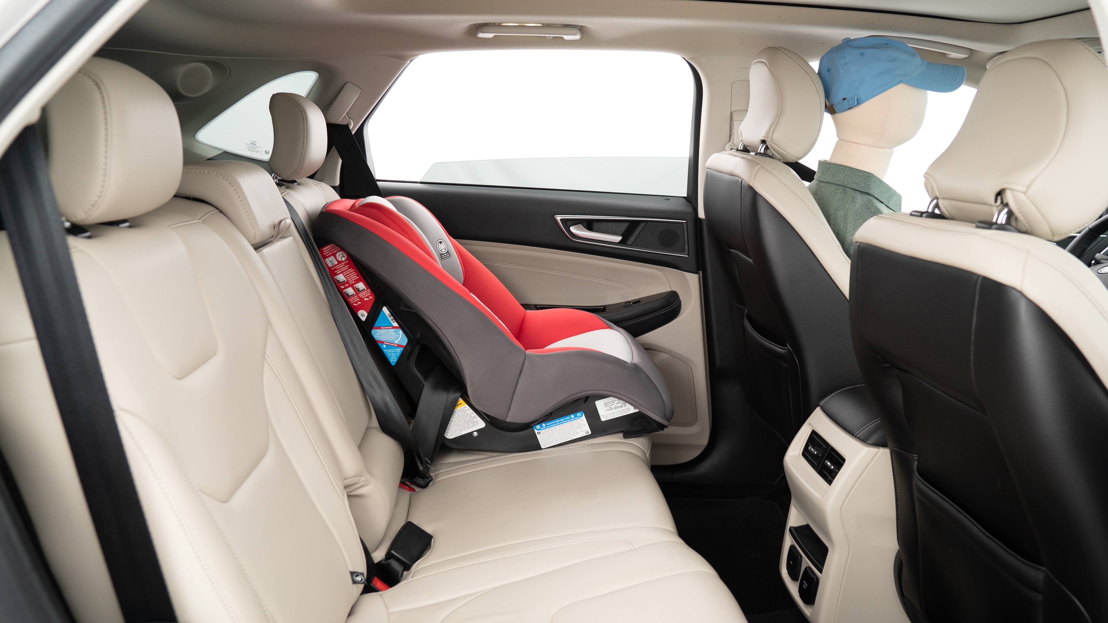 A series of second-row backseat photos is shown including one seating a baby seat, a dog and one seating a 6'1" mannequin.