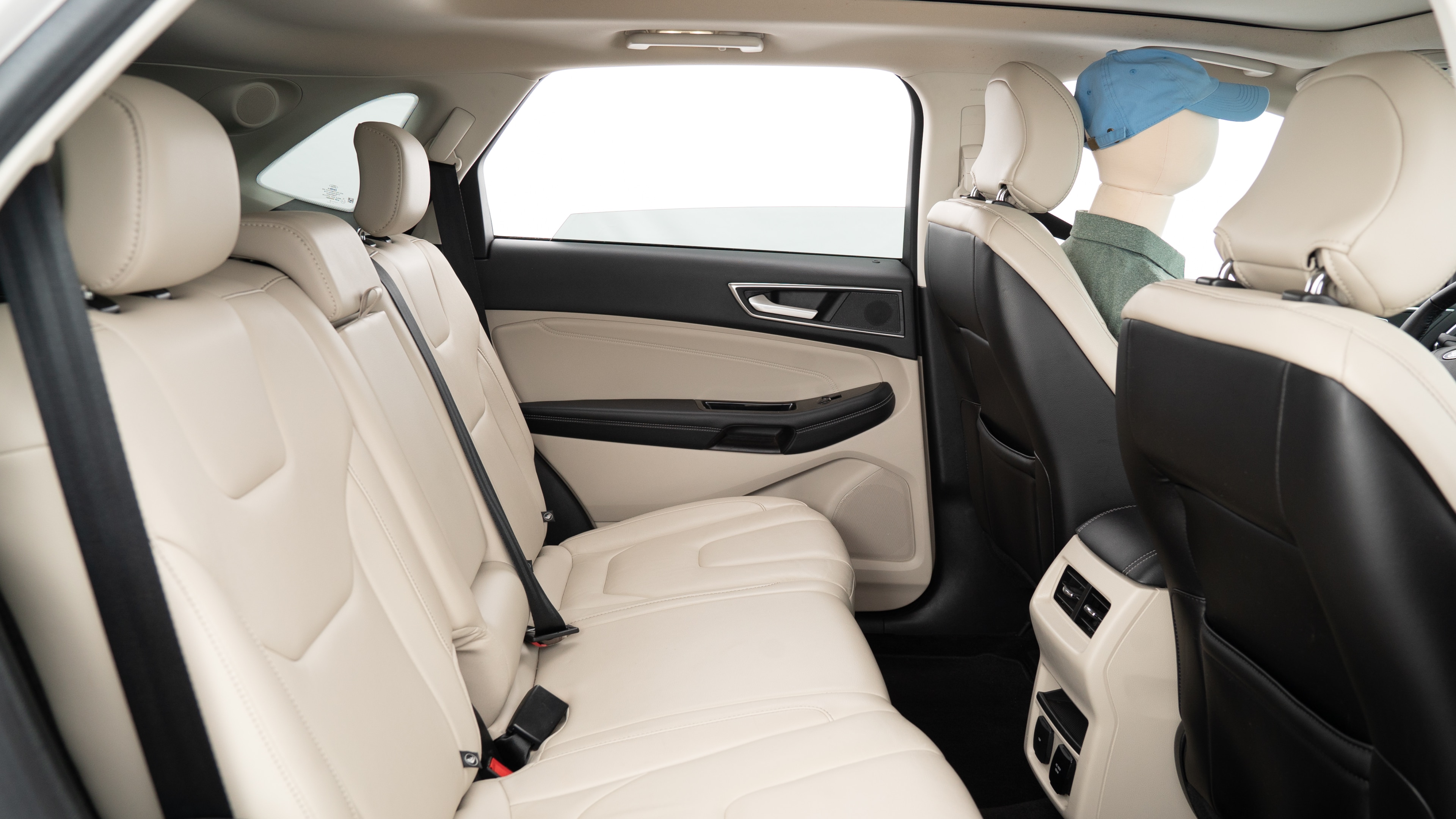 A series of second-row backseat photos is shown including one seating a baby seat, a dog and one seating a 6'1" mannequin.