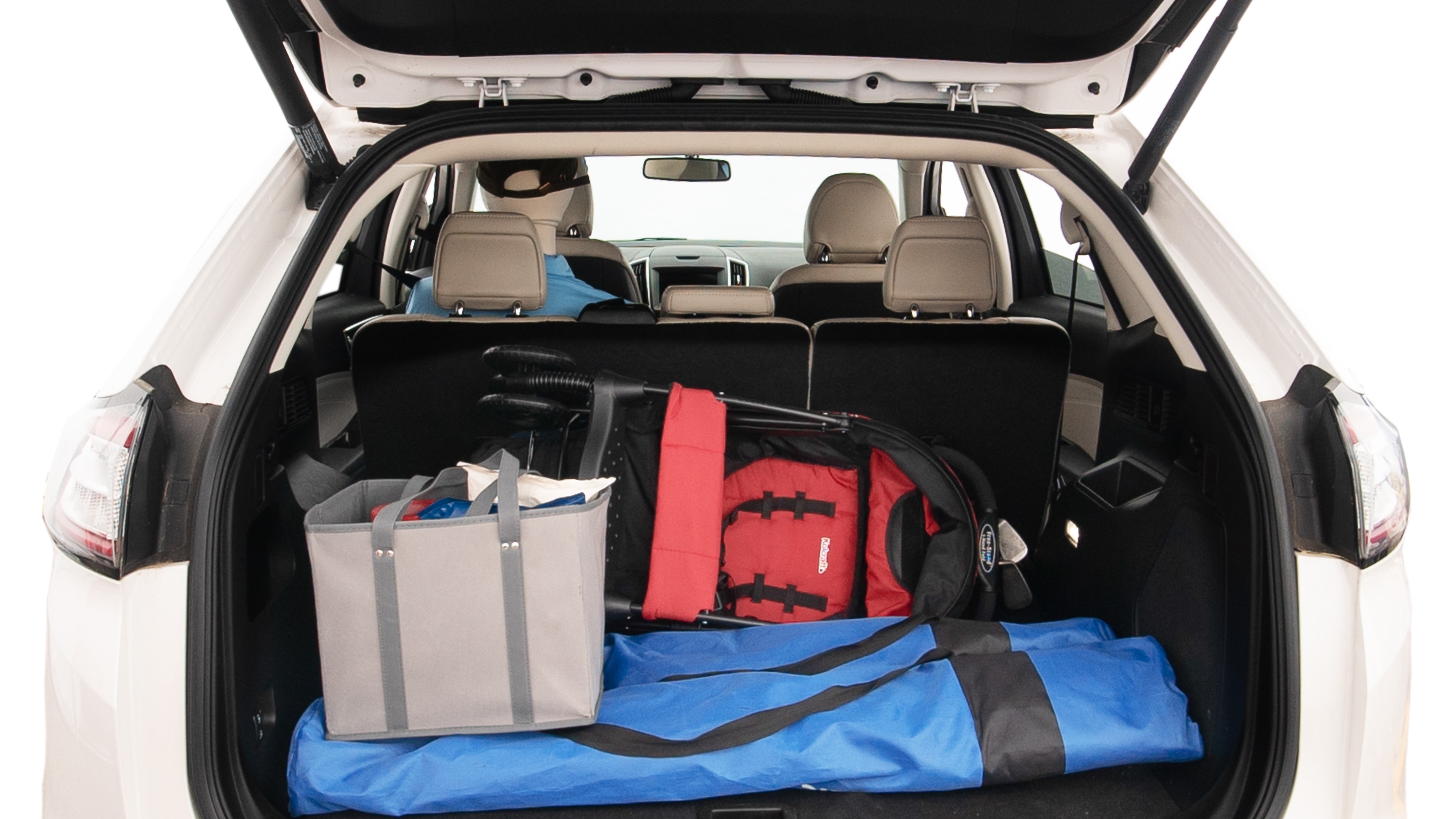 The trunk lid is open showing full view of the trunk. A baby stroller, three grocery carriers, two camping chairs in the carrying bag, and a set of golf clubs are placed inside.