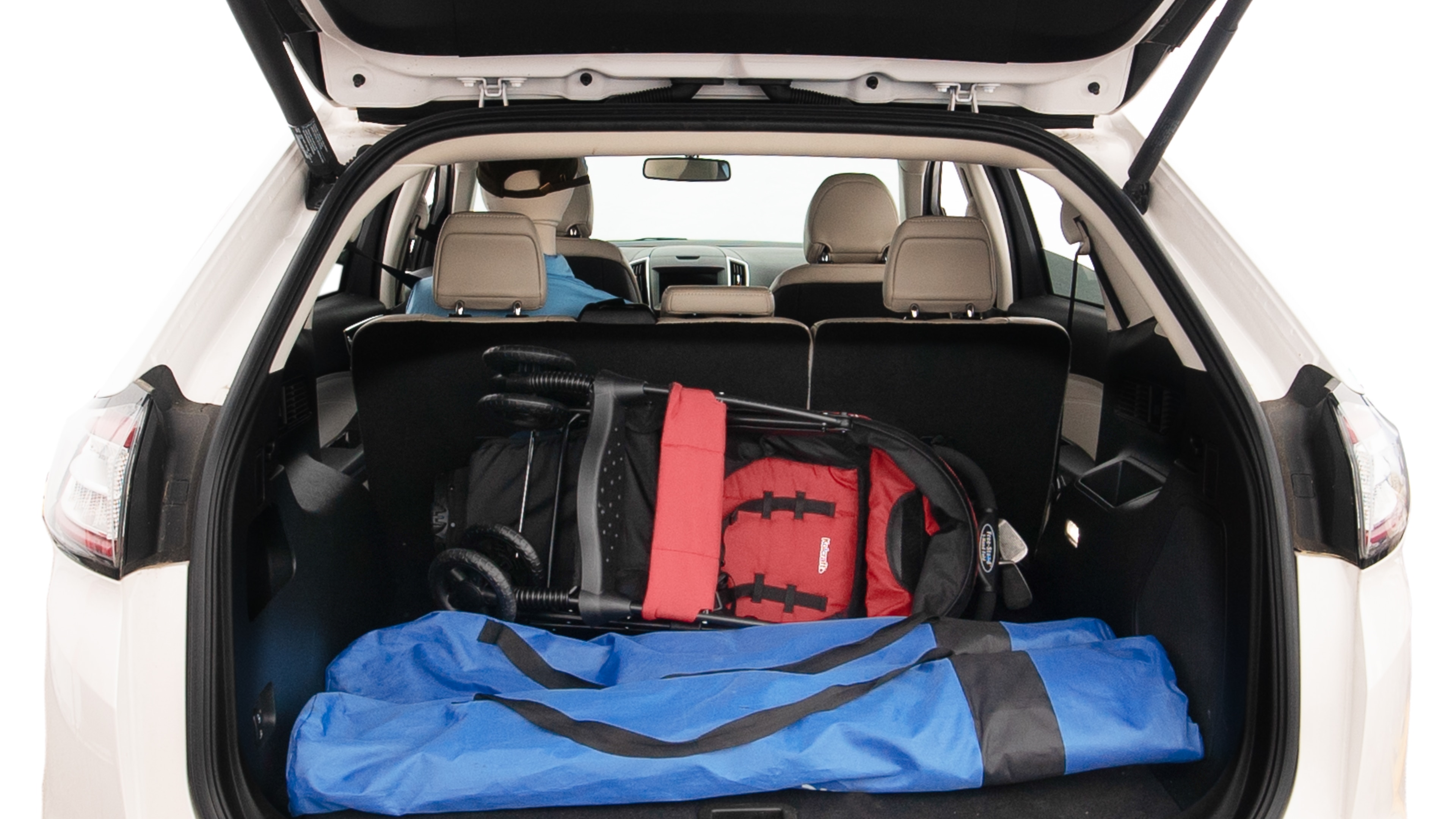 The trunk lid is open showing full view of the trunk. A baby stroller, three grocery carriers, two camping chairs in the carrying bag, and a set of golf clubs are placed inside.