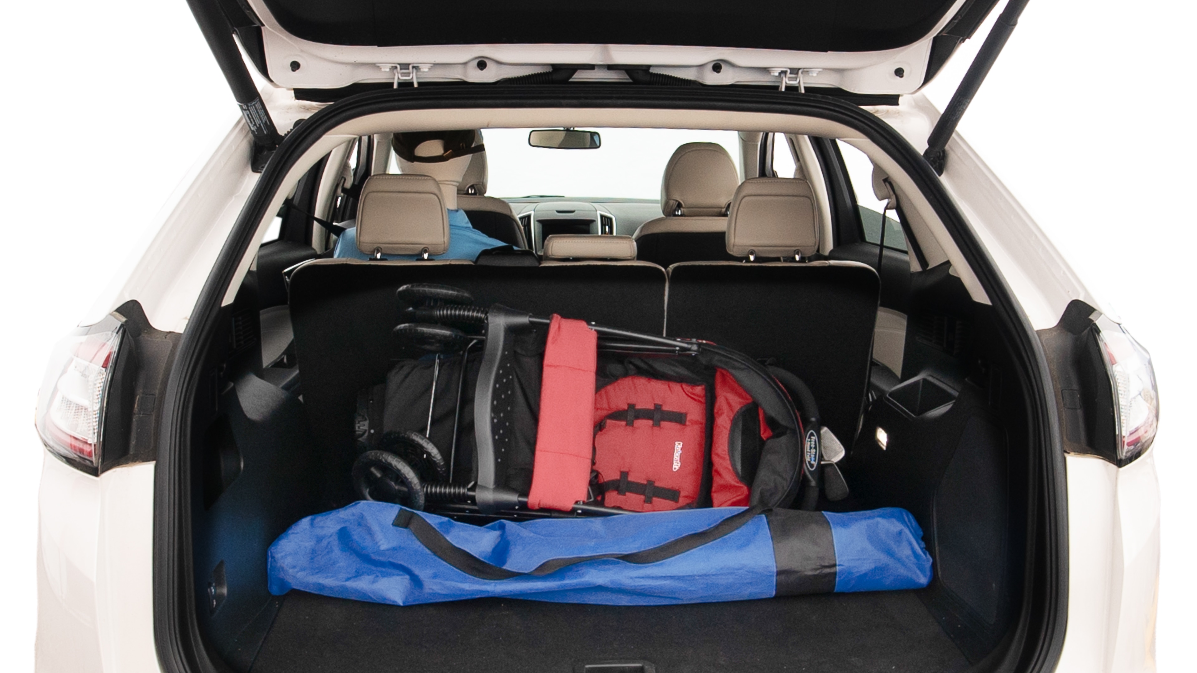 The trunk lid is open showing full view of the trunk. A baby stroller, three grocery carriers, two camping chairs in the carrying bag, and a set of golf clubs are placed inside.