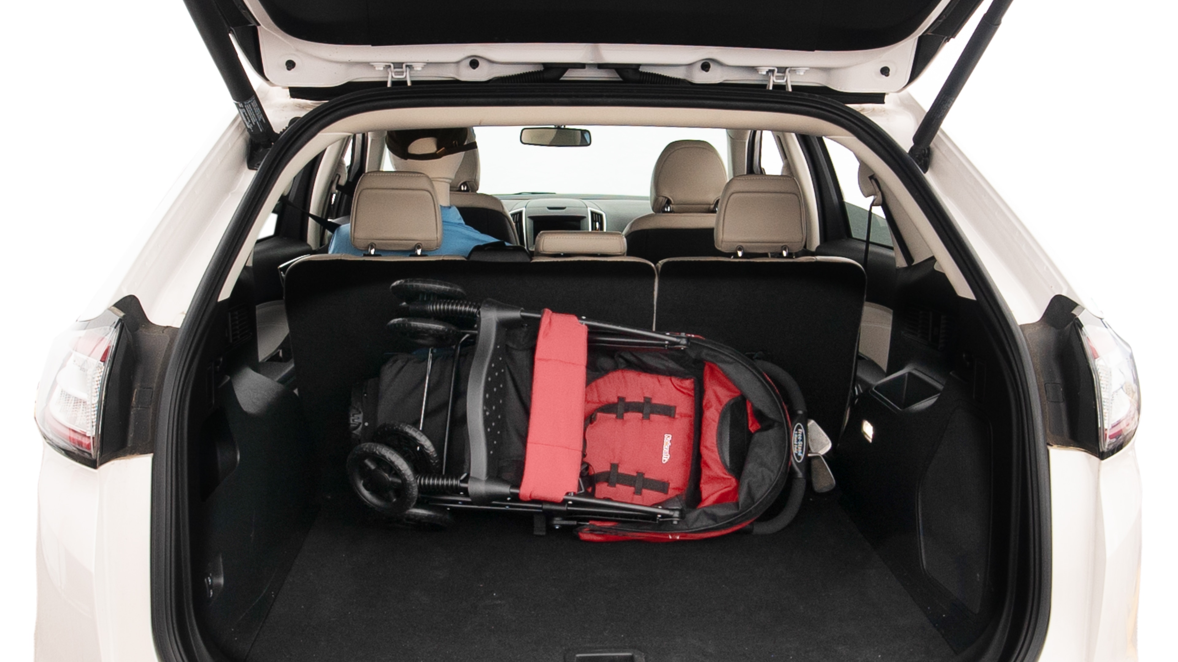 The trunk lid is open showing full view of the trunk. A baby stroller, three grocery carriers, two camping chairs in the carrying bag, and a set of golf clubs are placed inside.