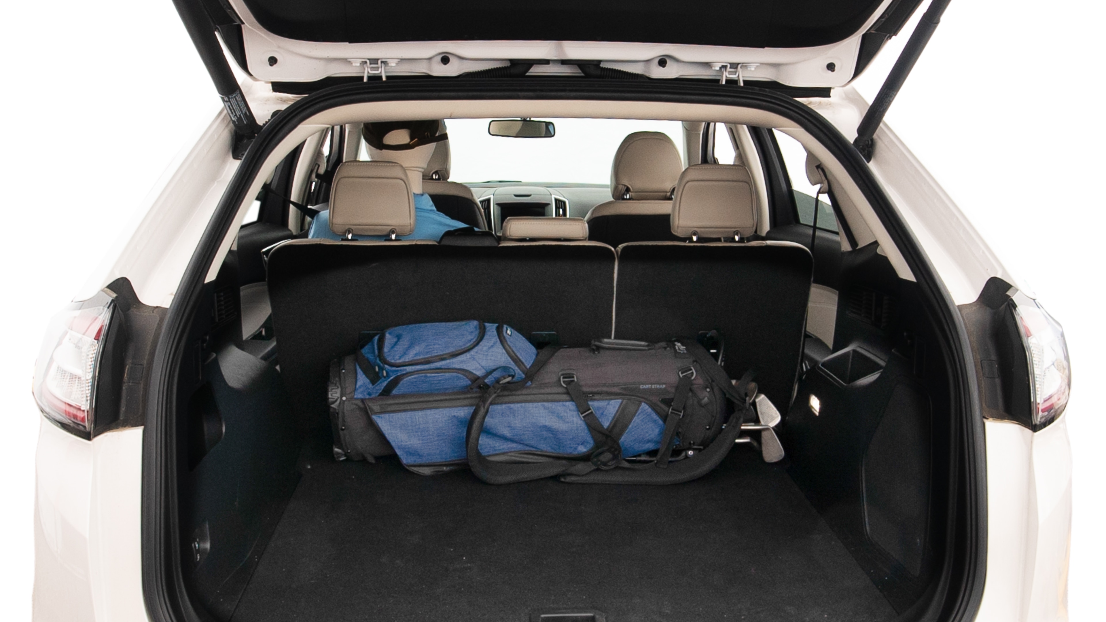 The trunk lid is open showing full view of the trunk. A baby stroller, three grocery carriers, two camping chairs in the carrying bag, and a set of golf clubs are placed inside.