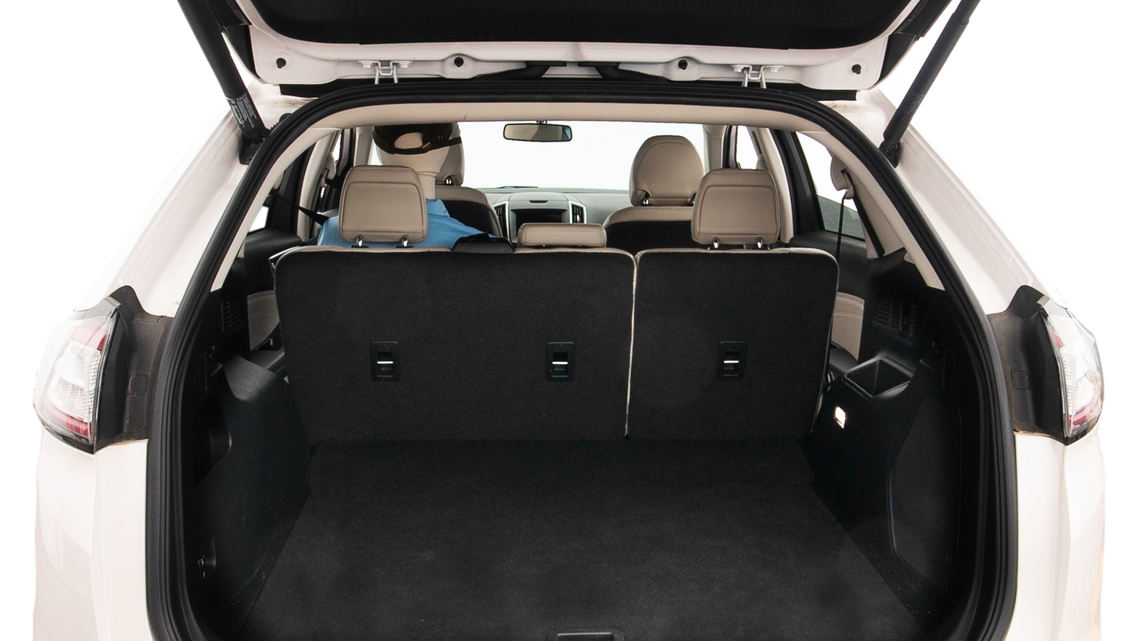 The trunk lid is open, showing full view of the trunk space. One extra large, Two large and two small suitcases are placed inside.