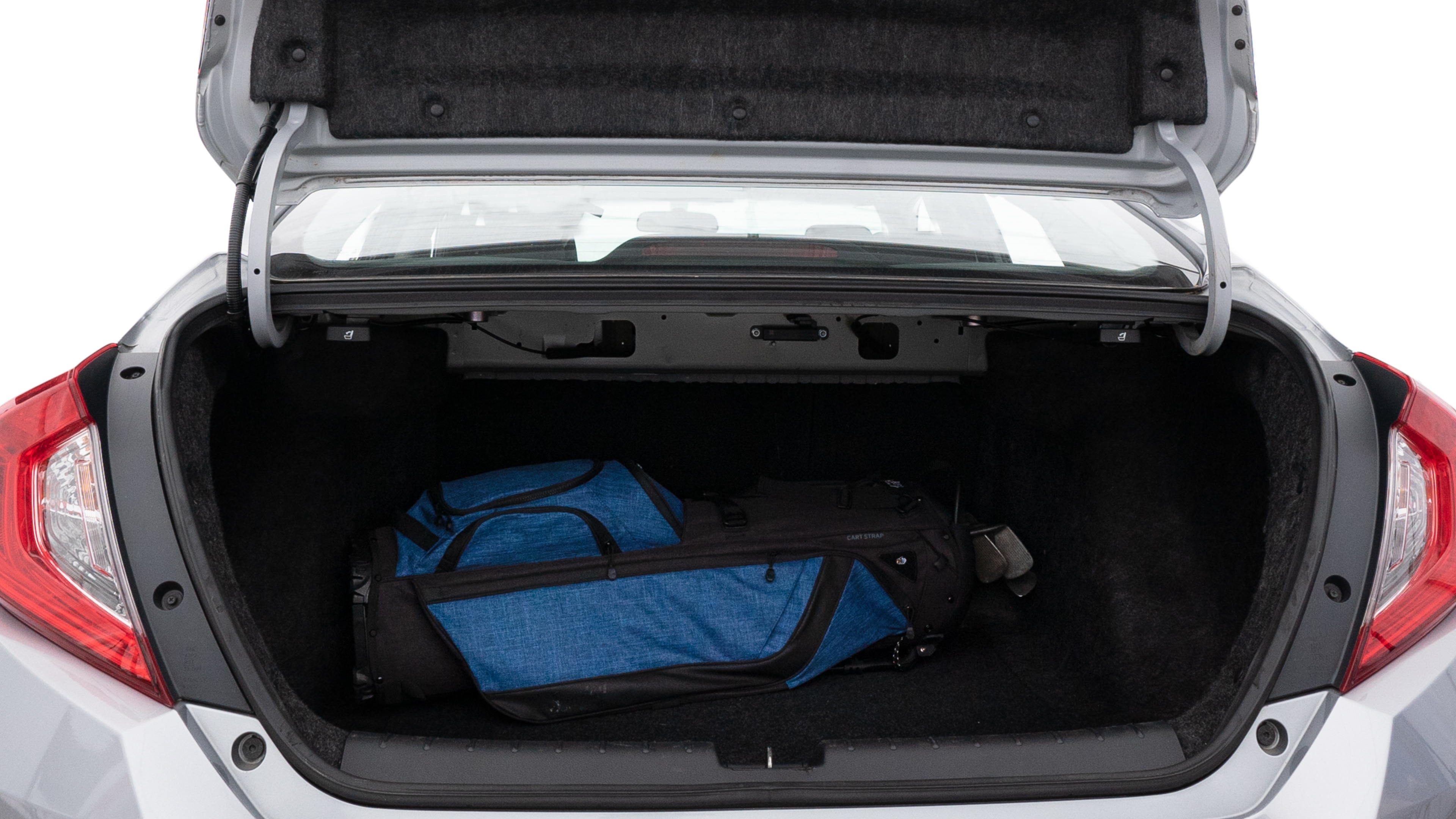 The trunk lid is open showing full view of the trunk. A baby stroller, three grocery carriers, two camping chairs in the carrying bag, and a set of golf clubs are placed inside.