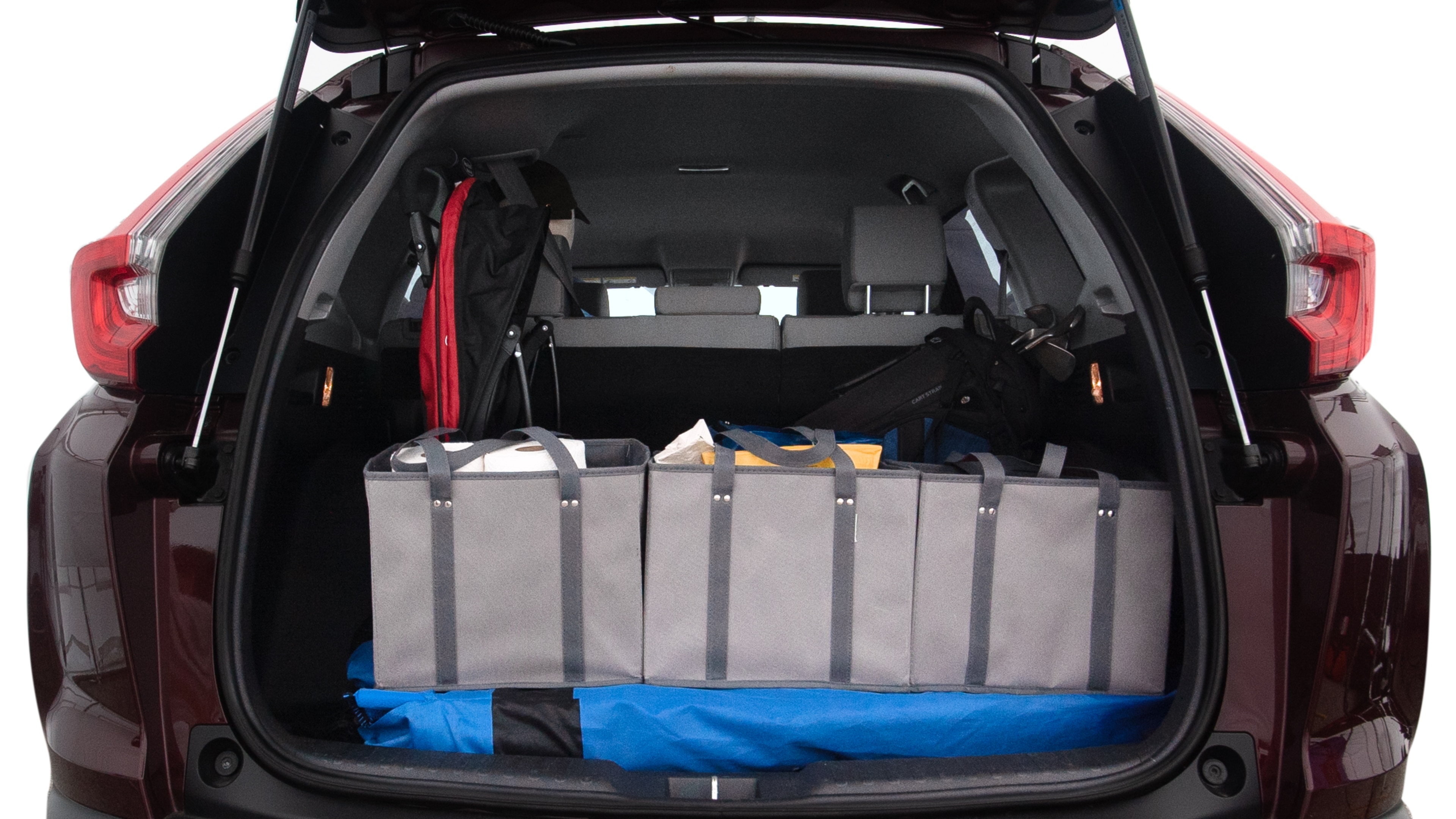 The trunk lid is open showing full view of the trunk. A baby stroller, three grocery carriers, two camping chairs in the carrying bag, and a set of golf clubs are placed inside.