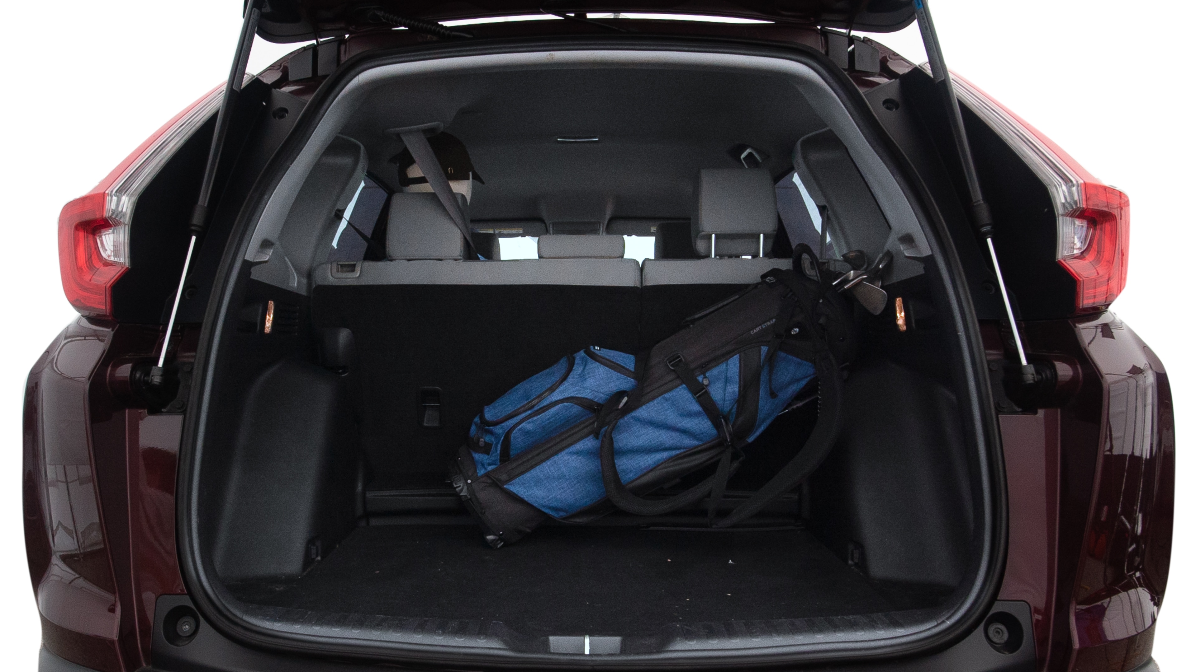 The trunk lid is open showing full view of the trunk. A baby stroller, three grocery carriers, two camping chairs in the carrying bag, and a set of golf clubs are placed inside.