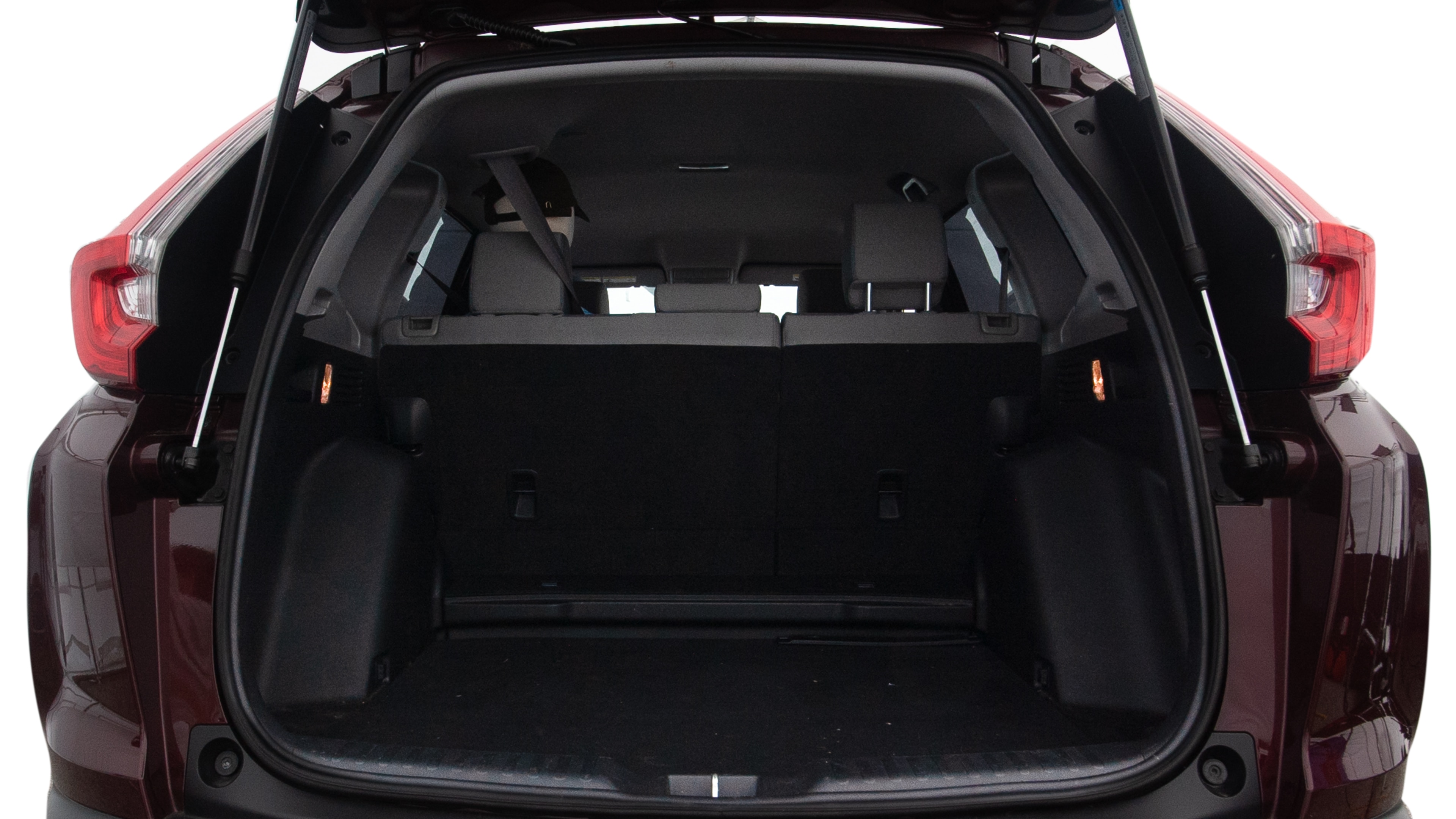 The trunk lid is open, showing full view of the trunk space. One large, two medium, and two small suitcases are placed inside.