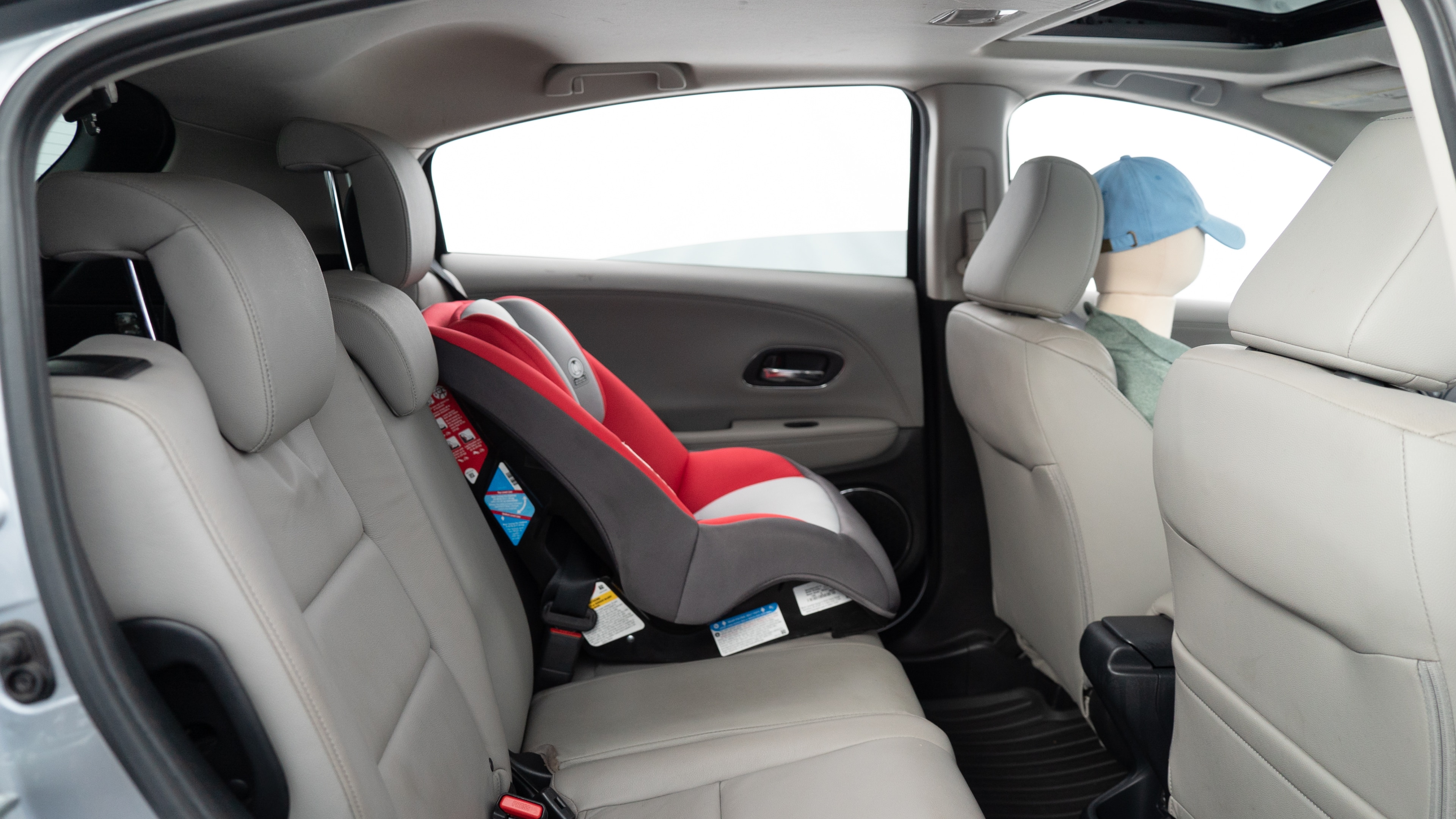 A series of second-row backseat photos is shown including one seating a baby seat, a dog and one seating a 6'1" mannequin.