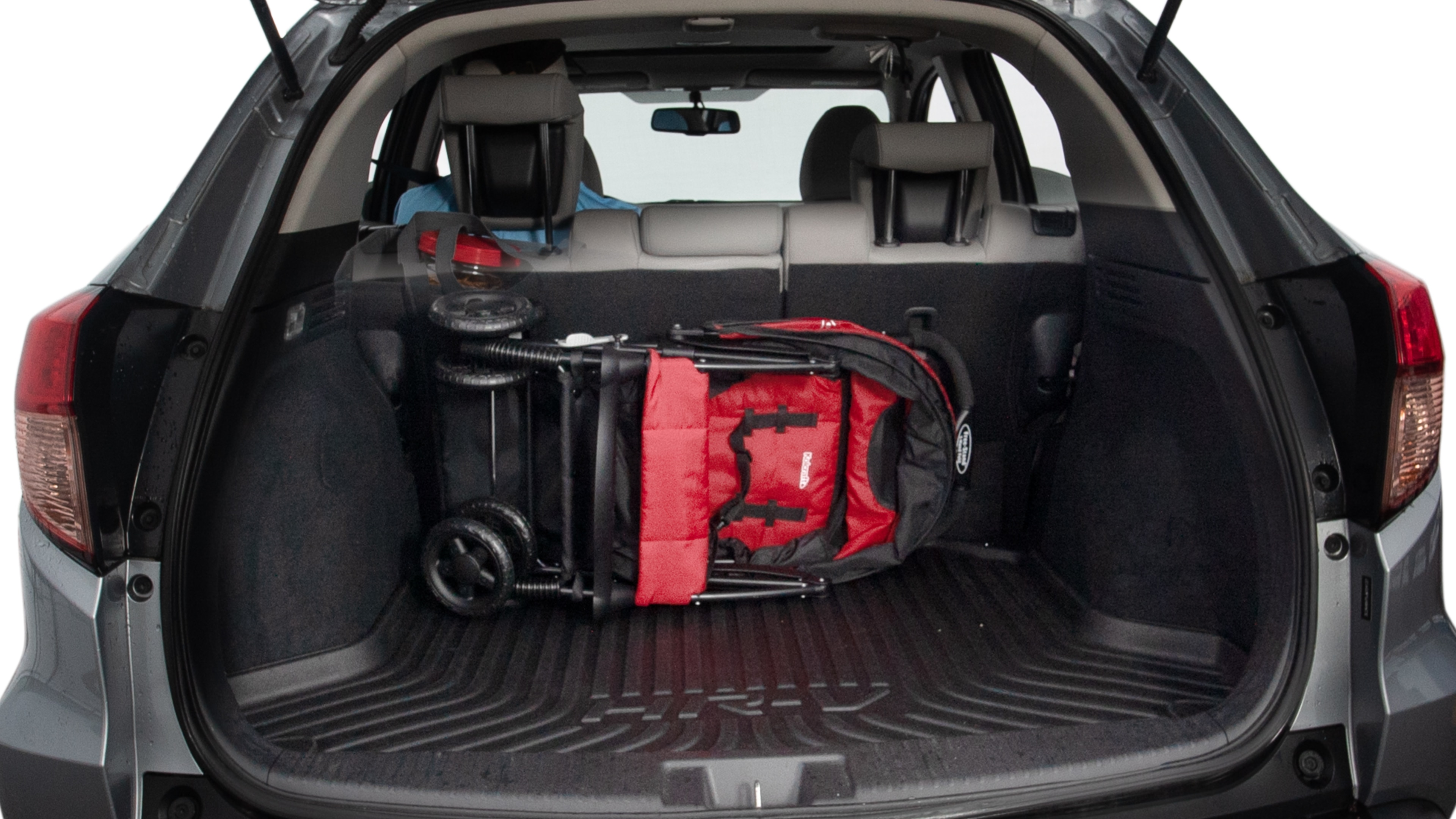 The trunk lid is open showing full view of the trunk. A baby stroller, three grocery carriers, two camping chairs in the carrying bag, and a set of golf clubs are placed inside.