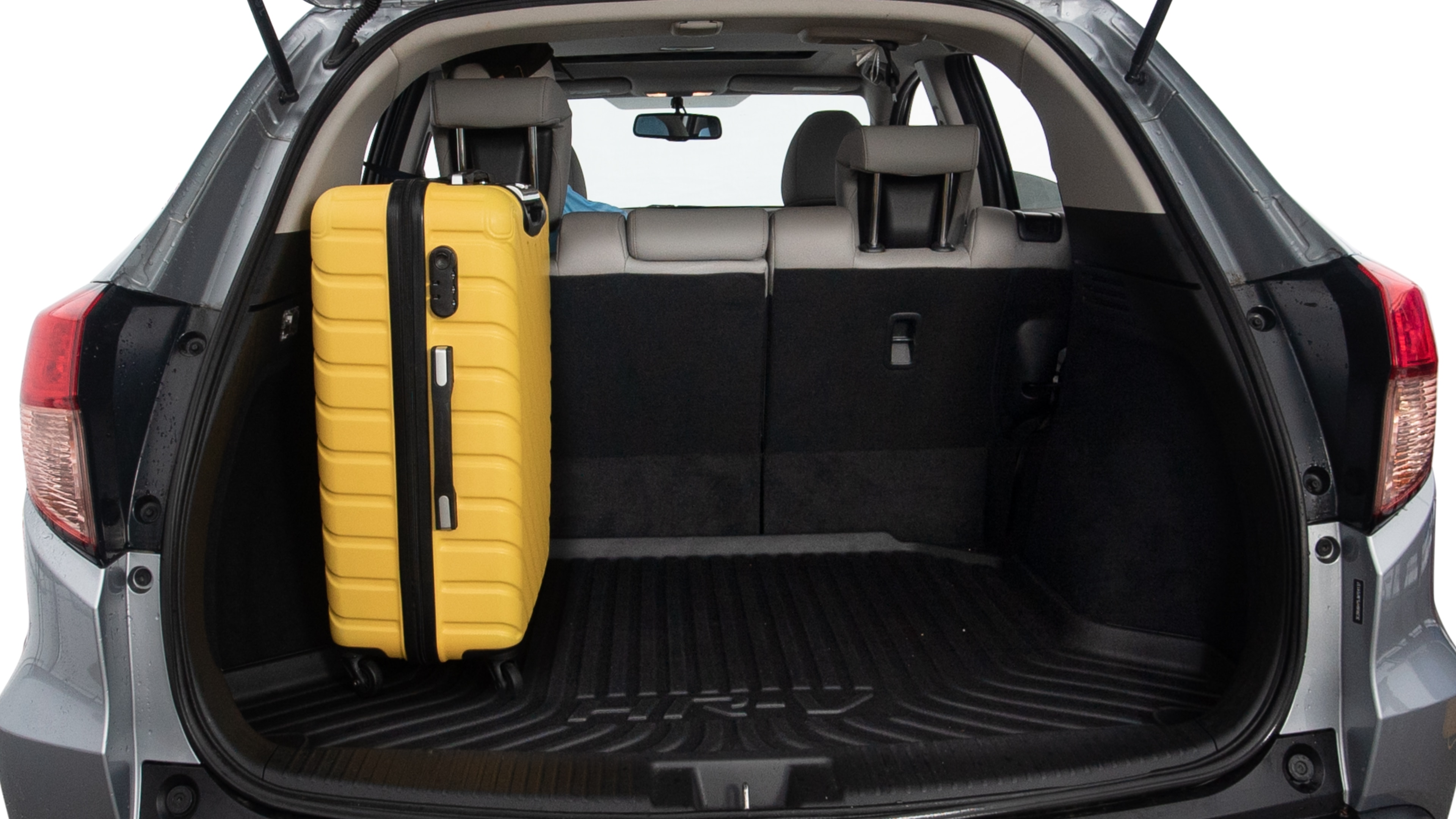 The trunk lid is open, showing full view of the trunk space. Two large and two small suitcases are placed inside.