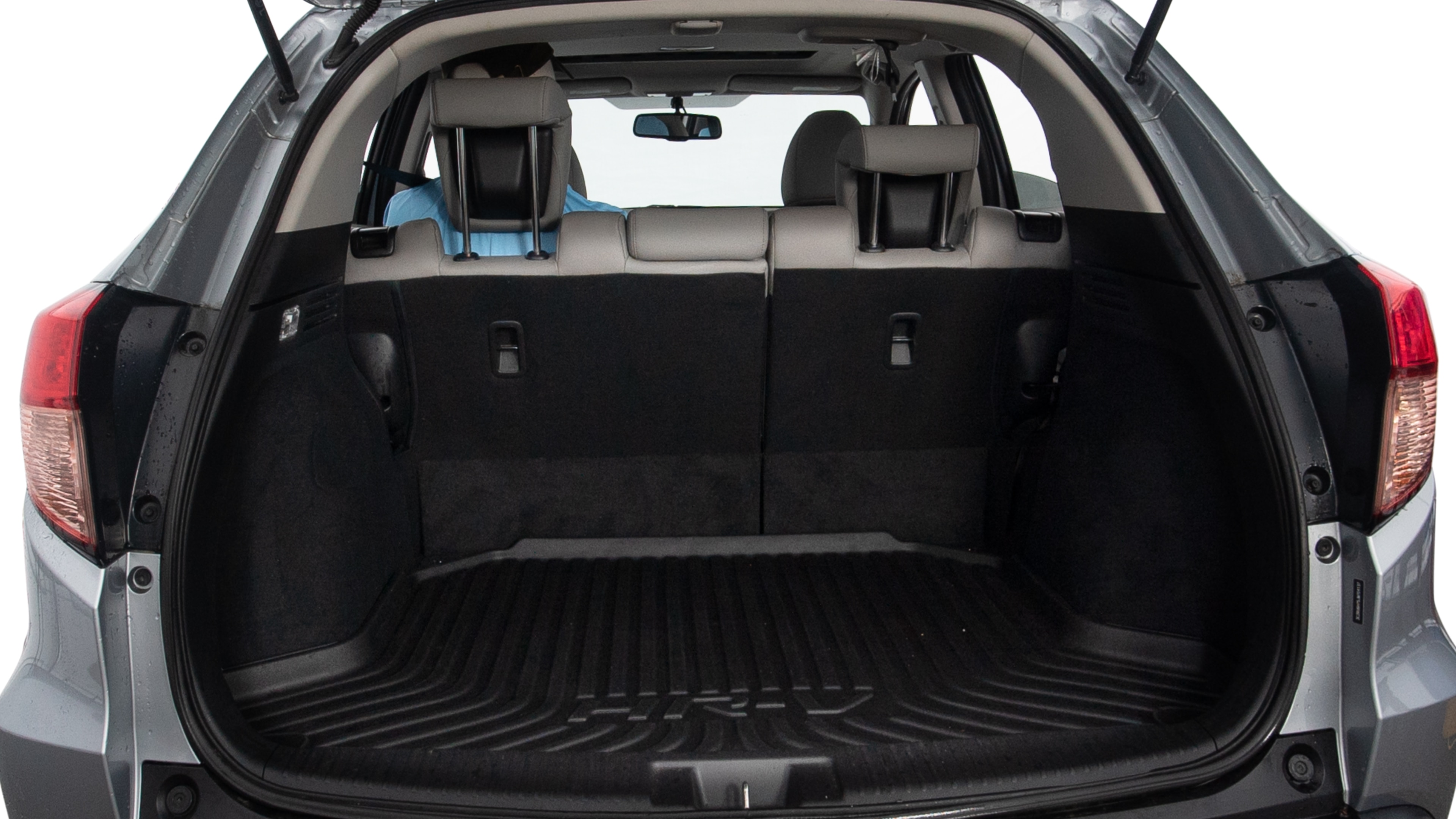 The trunk lid is open, showing full view of the trunk space. Two large and two small suitcases are placed inside.
