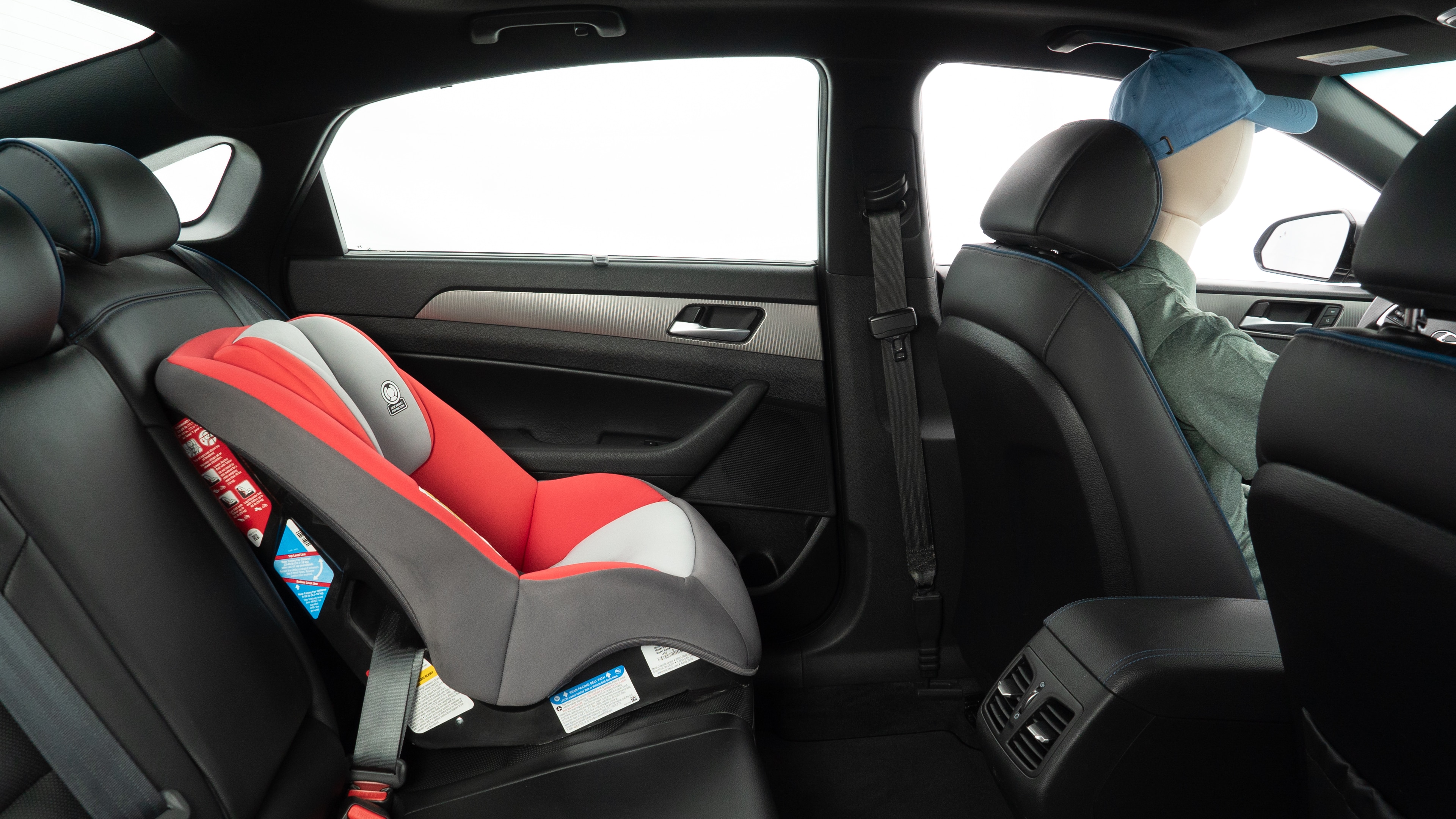 A series of second-row backseat photos is shown including one seating a baby seat and one seating a 6'1" mannequin.