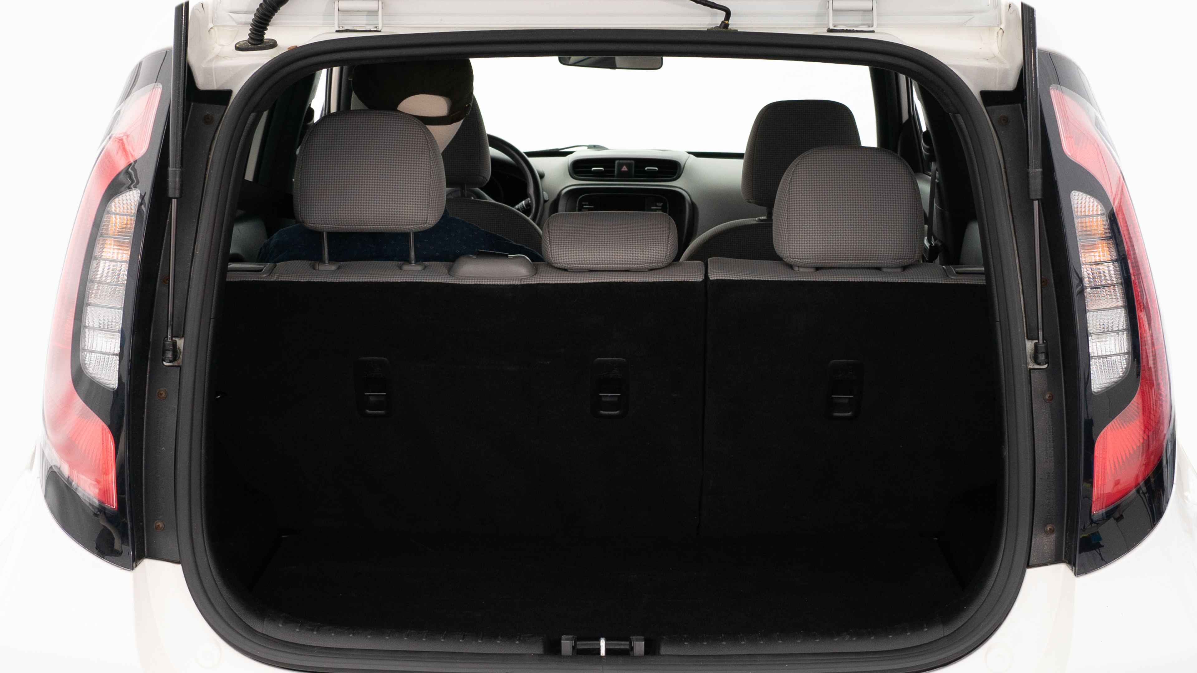 The trunk lid is open showing full view of the trunk. A baby stroller, three grocery carriers, and a set of golf clubs are placed inside.