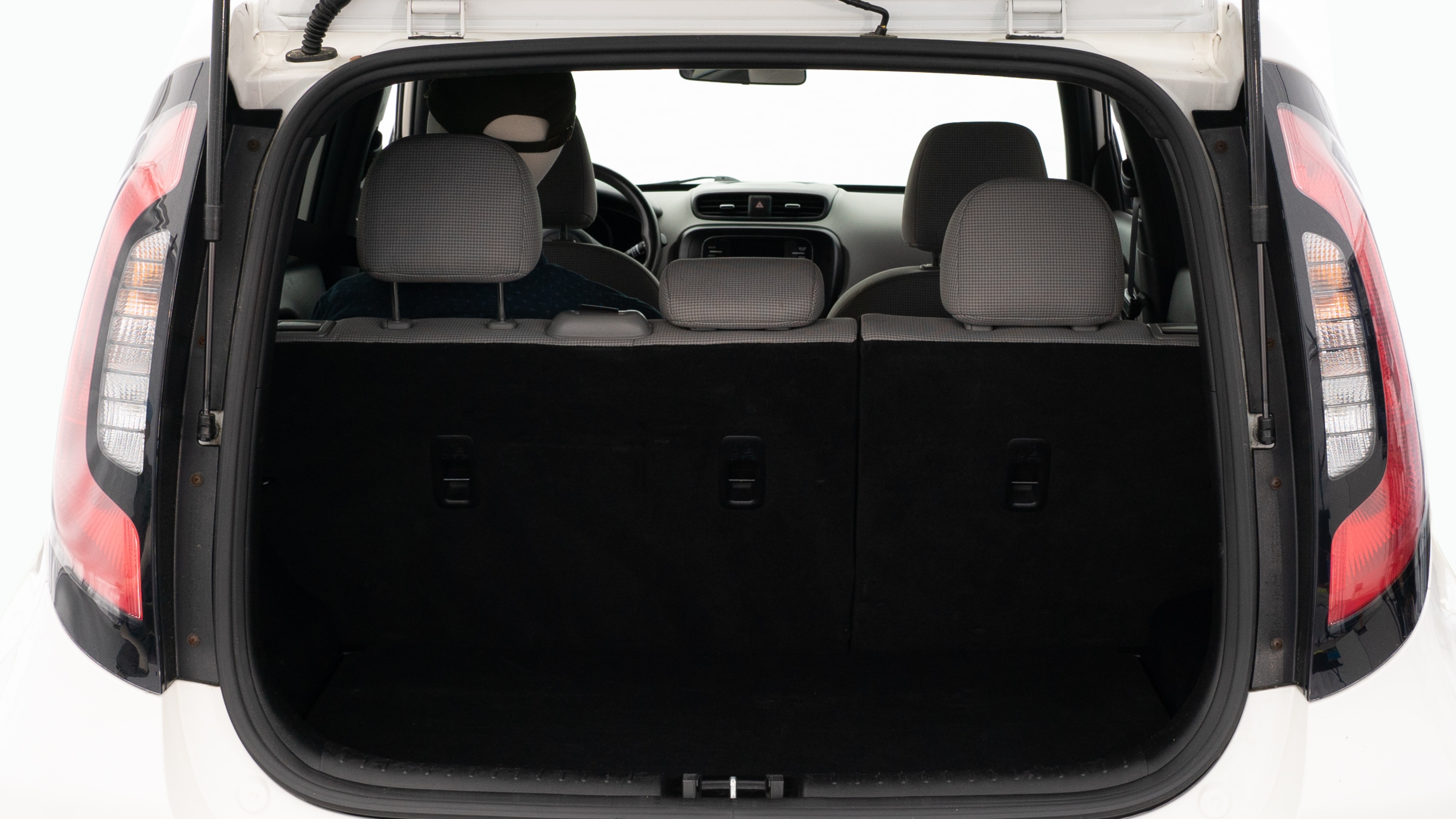 The trunk lid is open, showing a full view of the trunk space. Two large and two small suitcases are placed on there side.