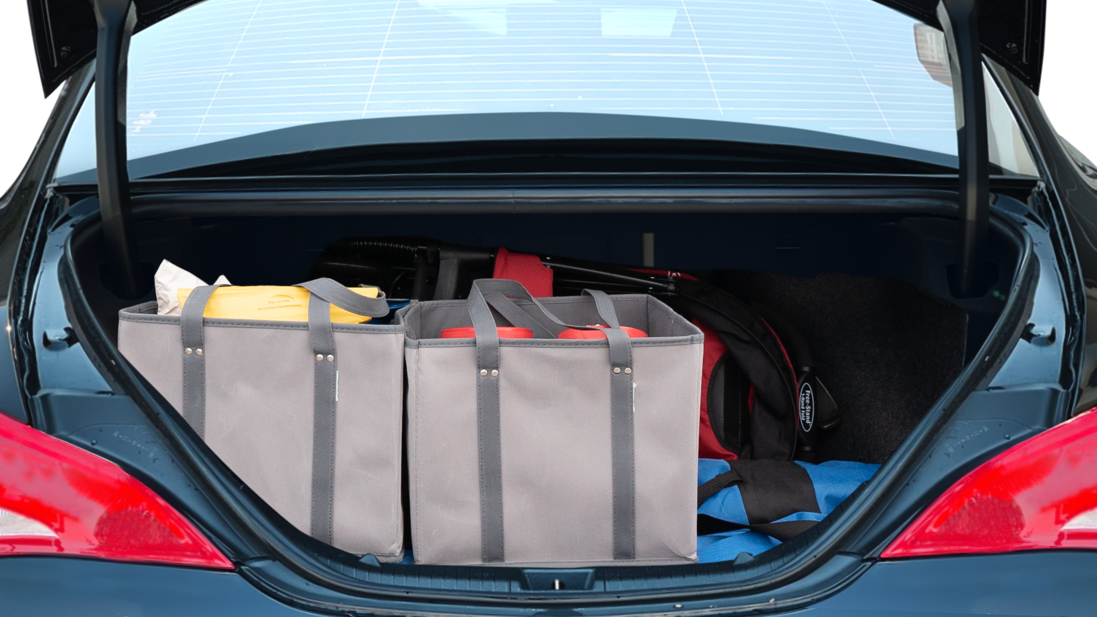 The trunk lid is open showing full view of the trunk. A baby stroller, three grocery carriers, two camping chairs in the carrying bag, and a set of golf clubs are placed inside.