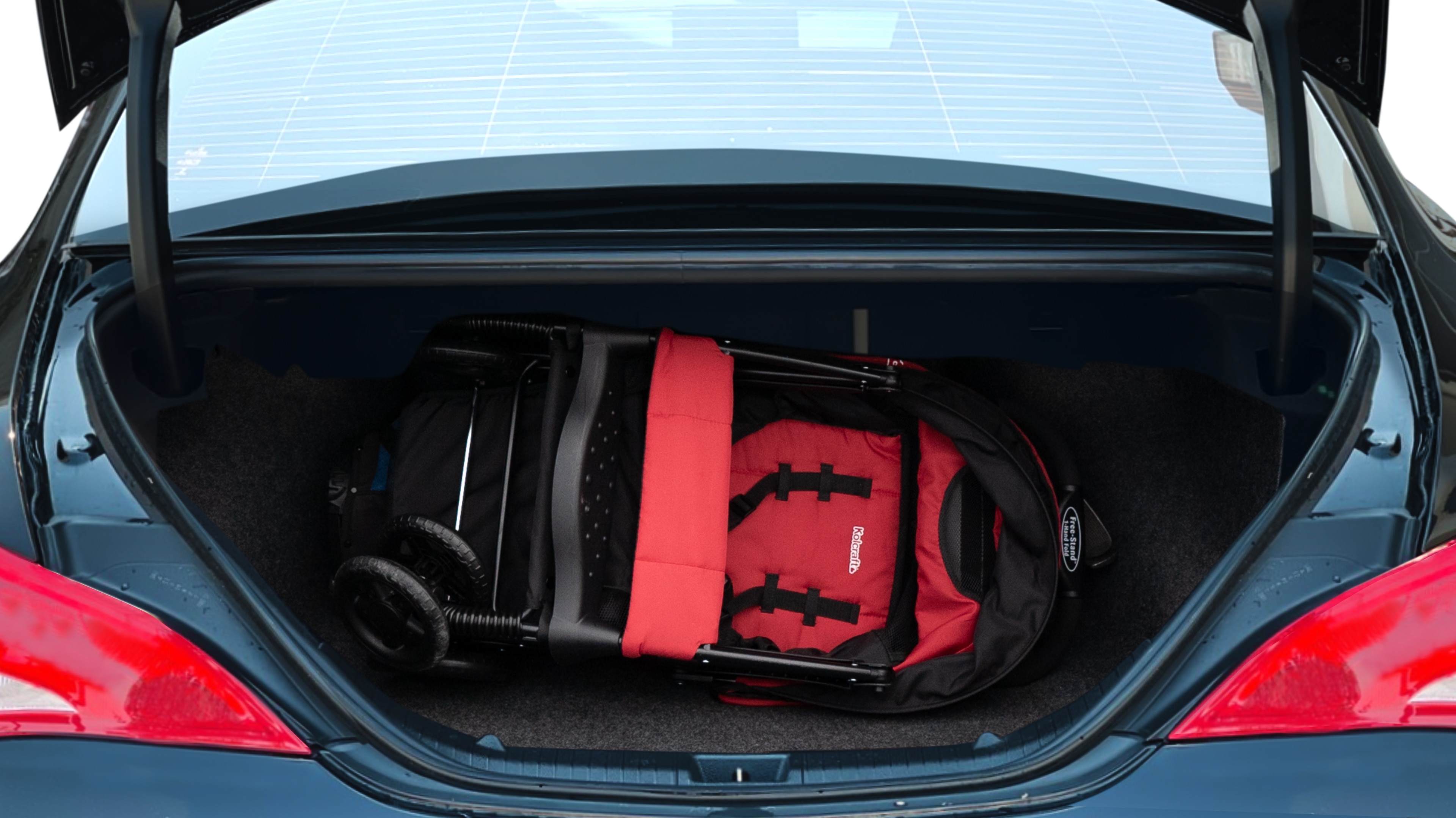 The trunk lid is open showing full view of the trunk. A baby stroller, three grocery carriers, two camping chairs in the carrying bag, and a set of golf clubs are placed inside.