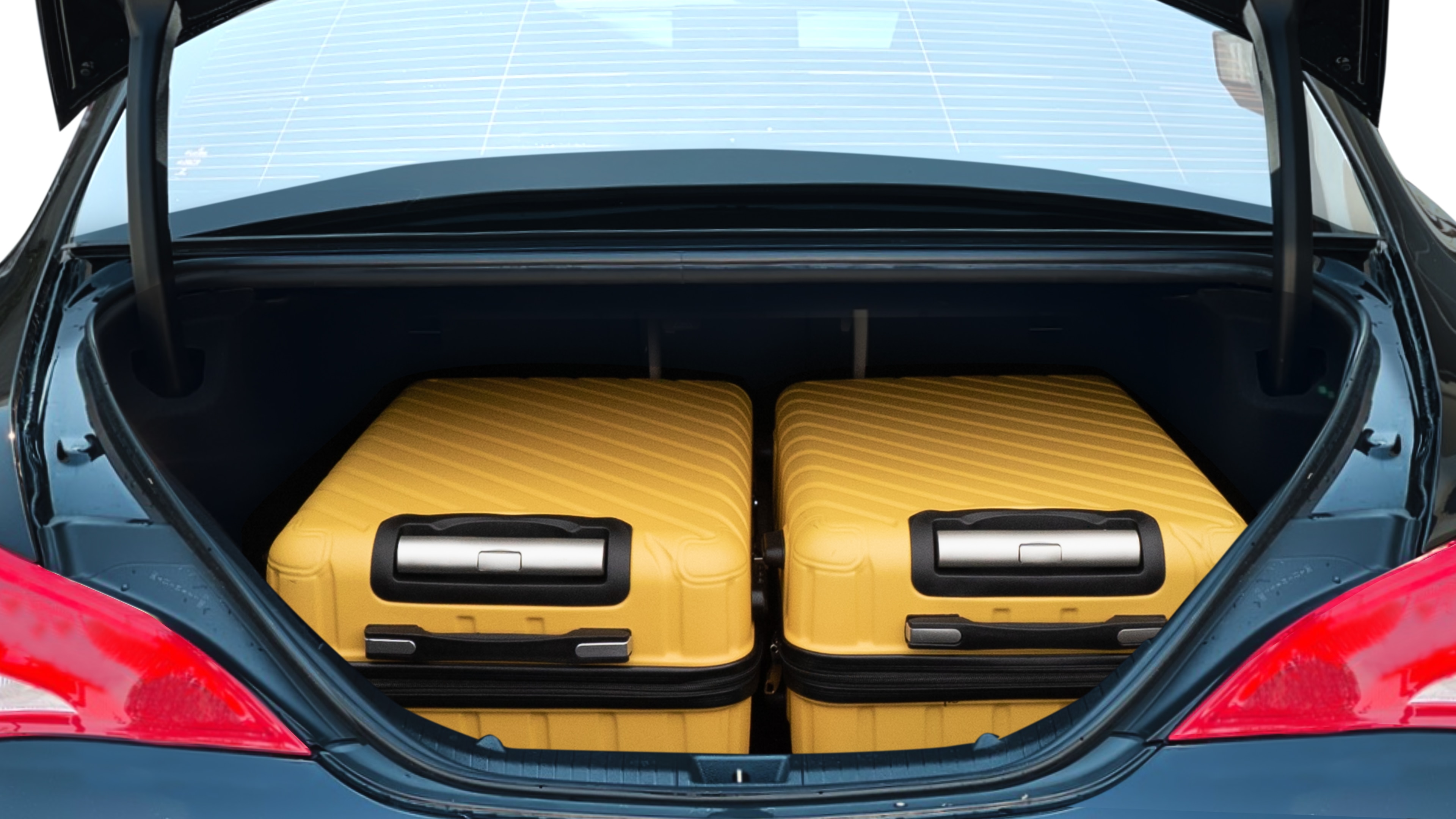 The trunk lid is open, showing full view of the trunk space. One large and two medium suitcases are placed inside.