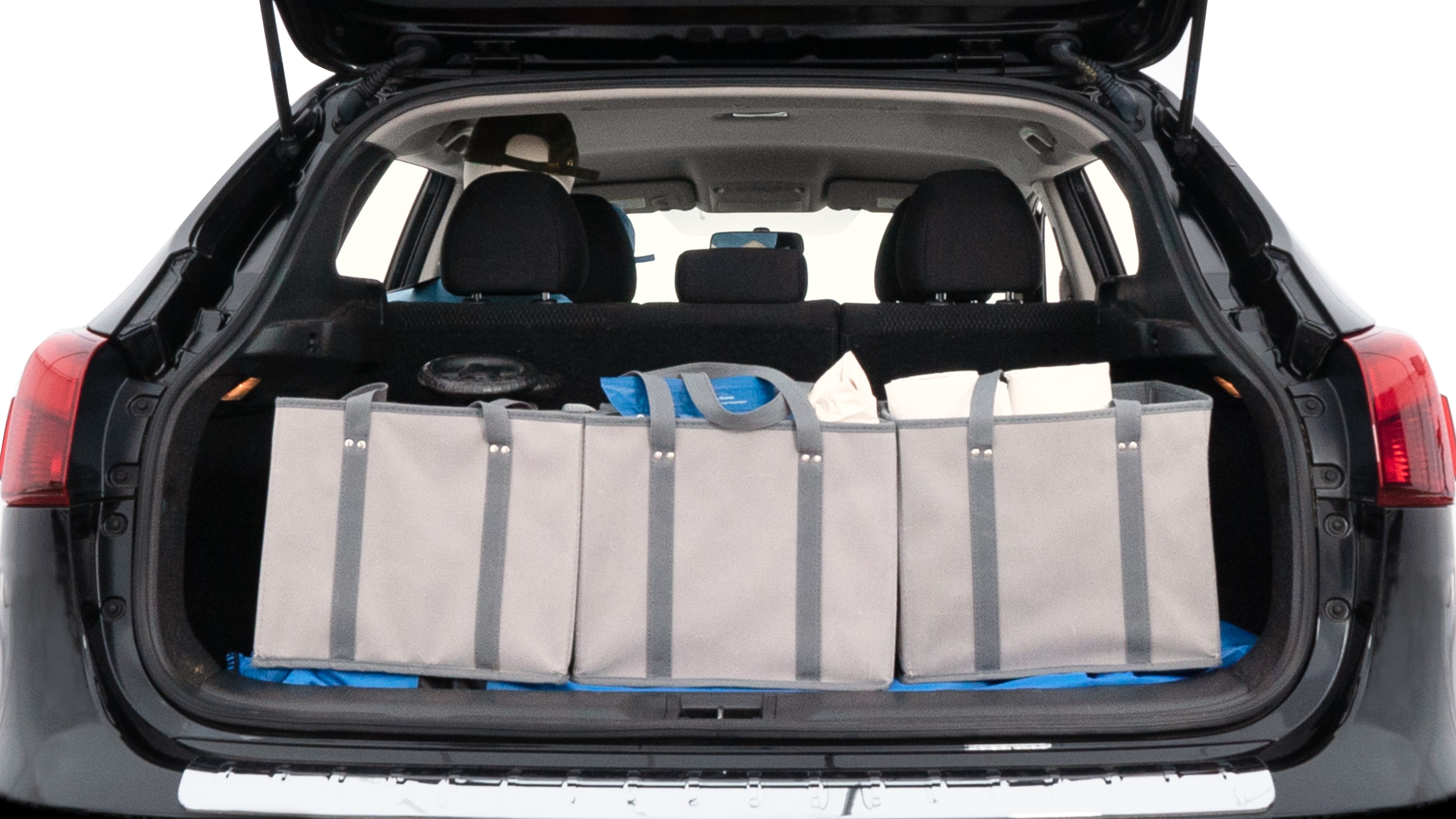 The trunk lid is open showing full view of the trunk. A baby stroller, three grocery carriers, two camping chairs in the carrying bag, and a set of golf clubs are placed inside.