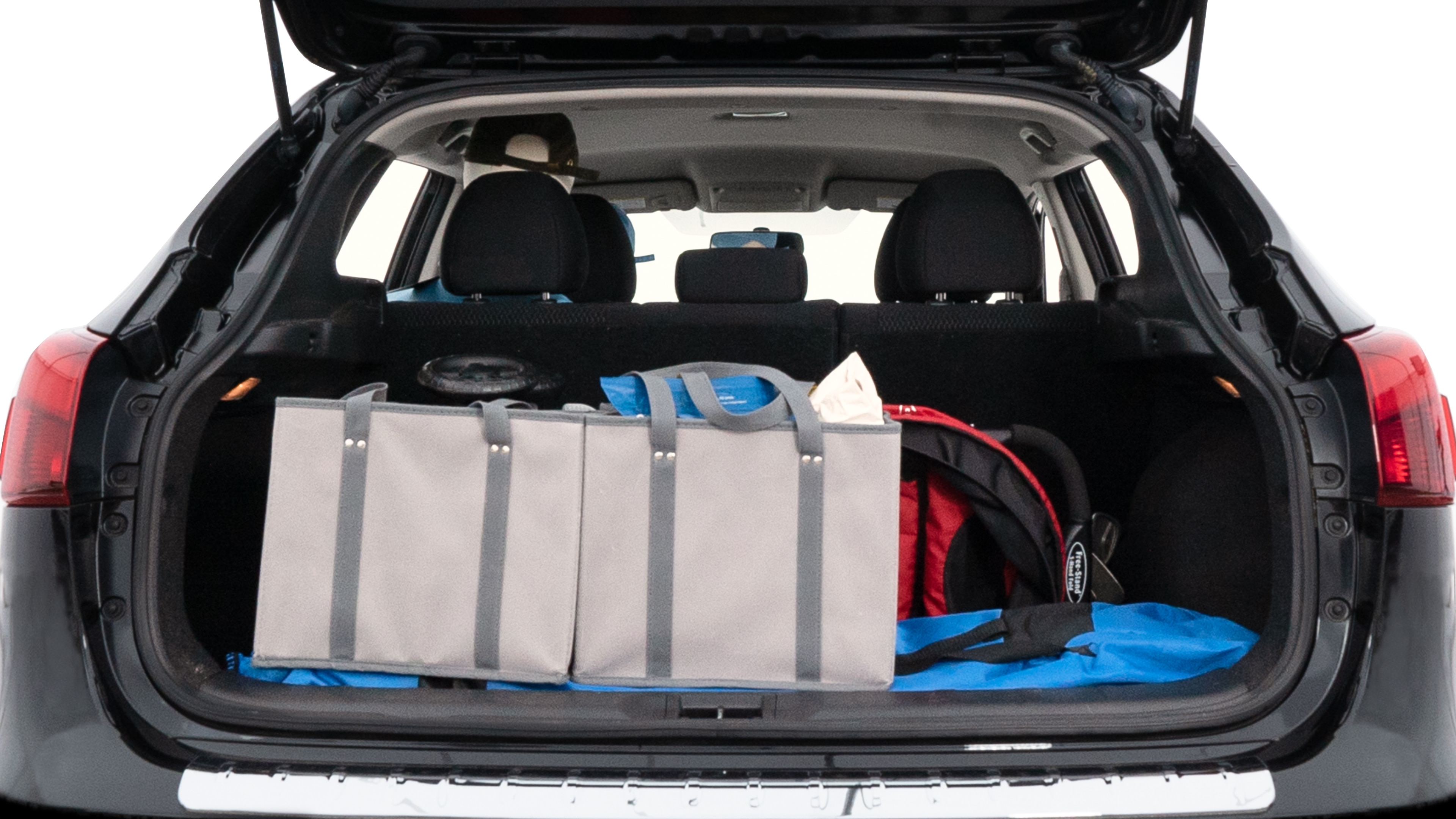 The trunk lid is open showing full view of the trunk. A baby stroller, three grocery carriers, two camping chairs in the carrying bag, and a set of golf clubs are placed inside.