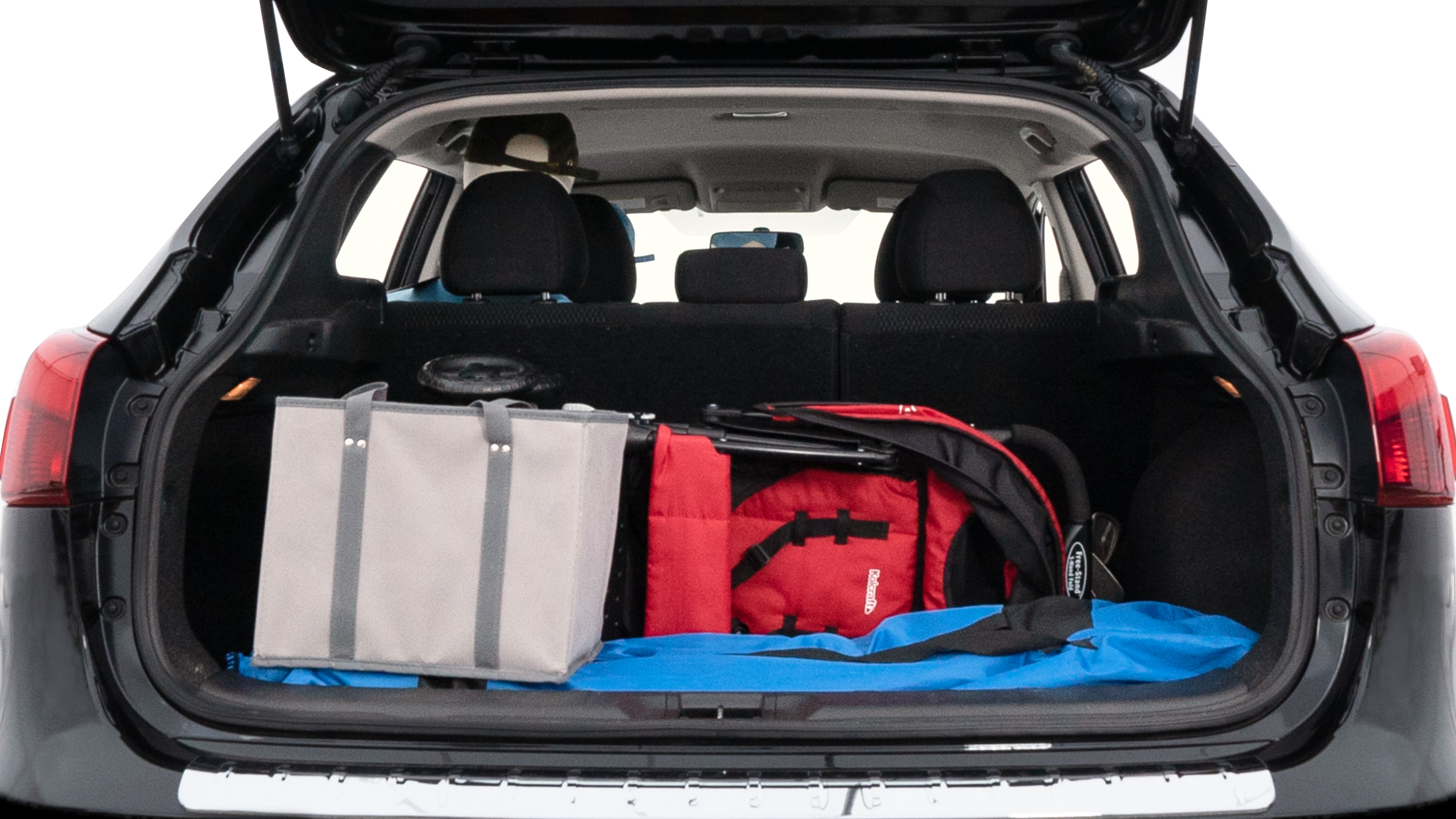 The trunk lid is open showing full view of the trunk. A baby stroller, three grocery carriers, two camping chairs in the carrying bag, and a set of golf clubs are placed inside.